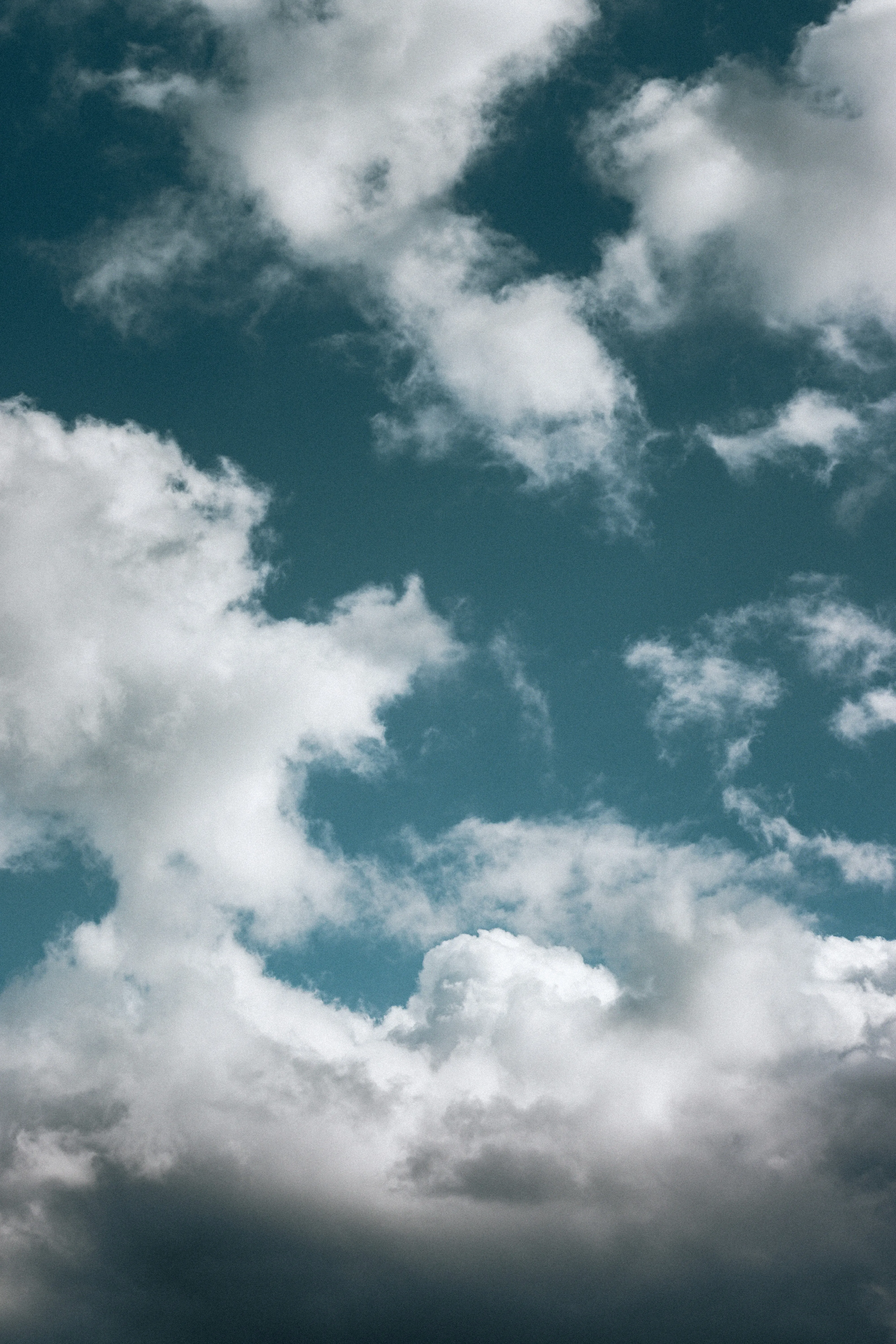 Bright White Clouds Moving Through a Vibrant Sky Image