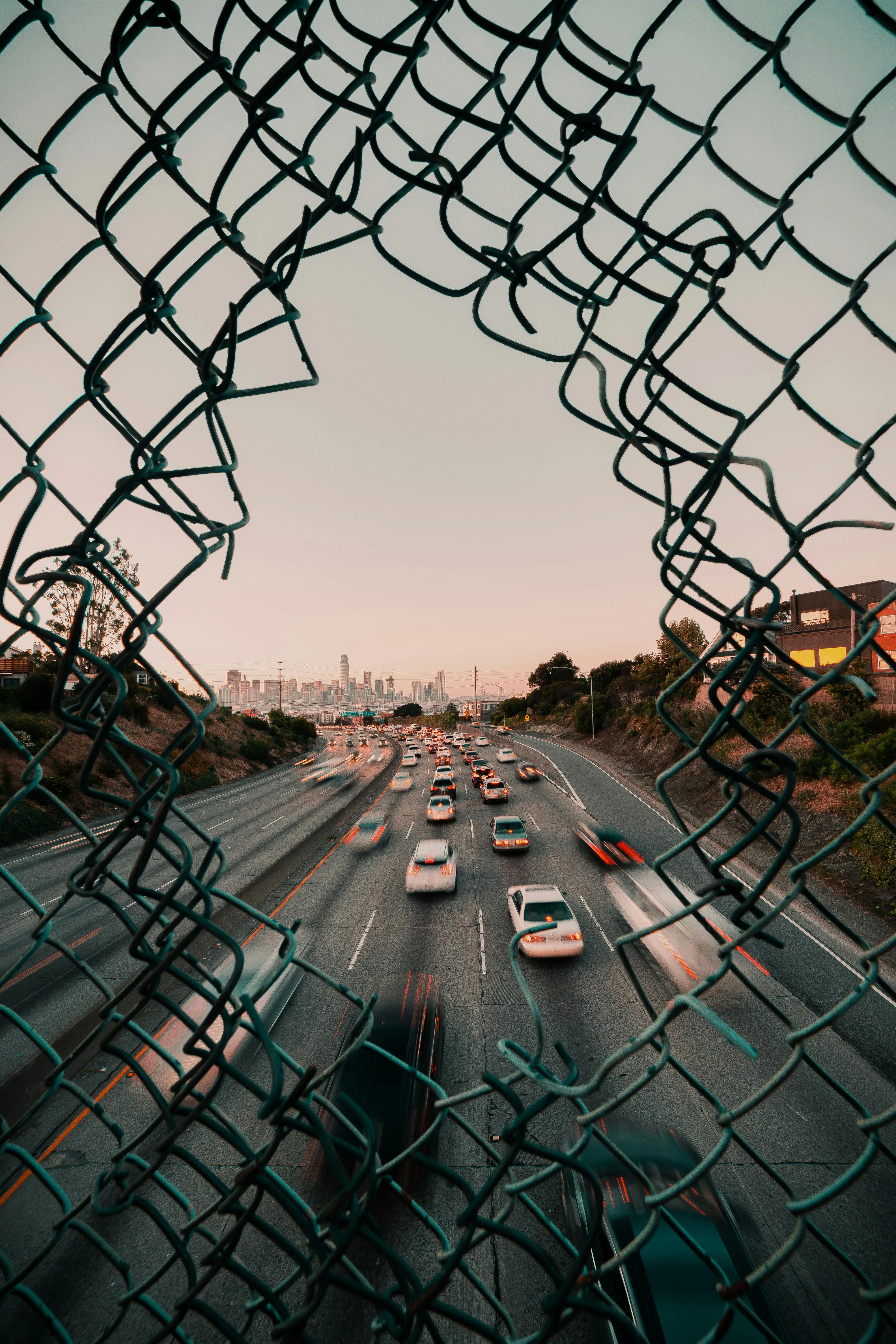 Busy City Traffic Through Artistic Fence in Golden Hour
