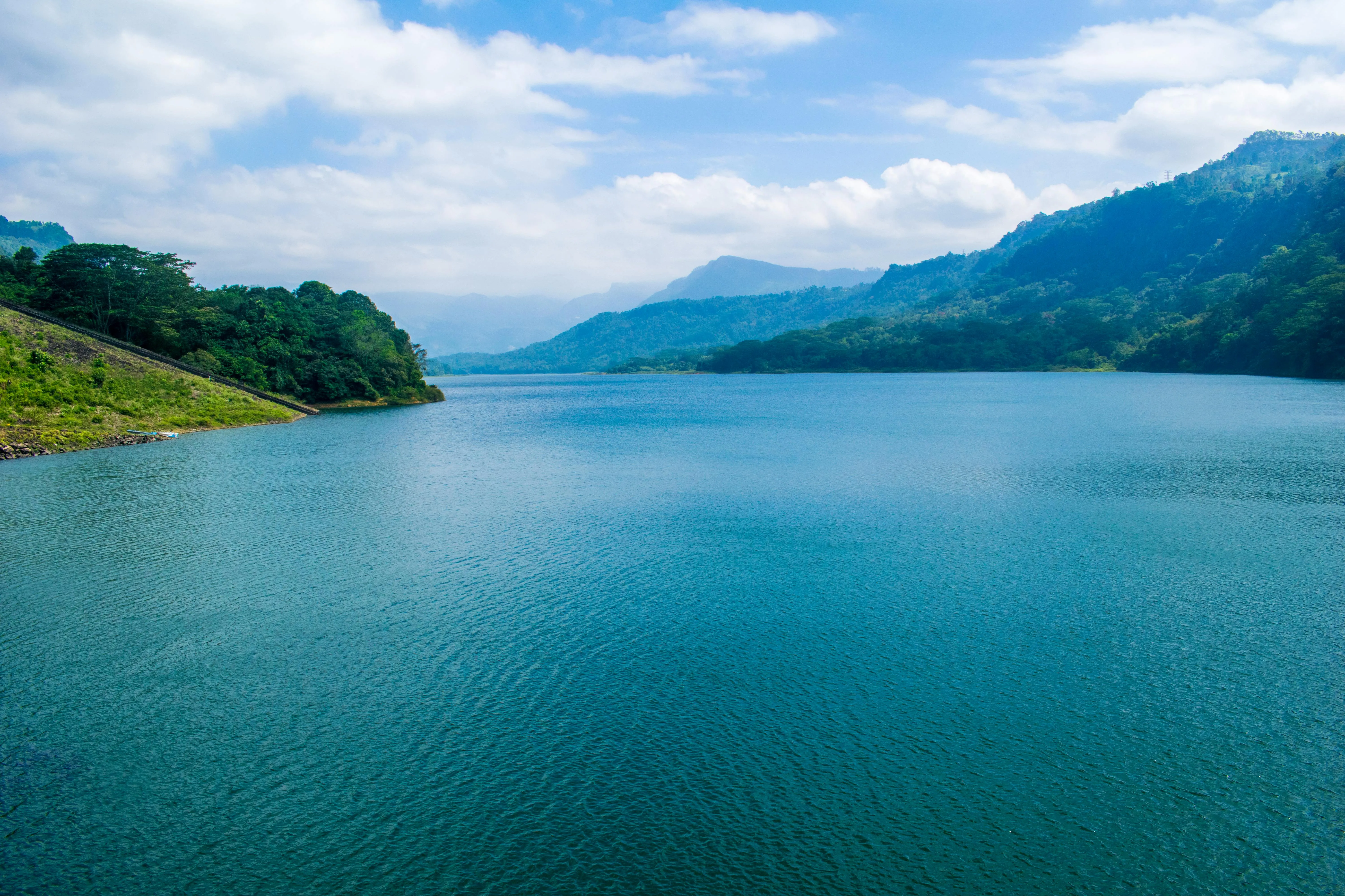 Calm Blue Lake Surrounded By Hills Under Clear Skies