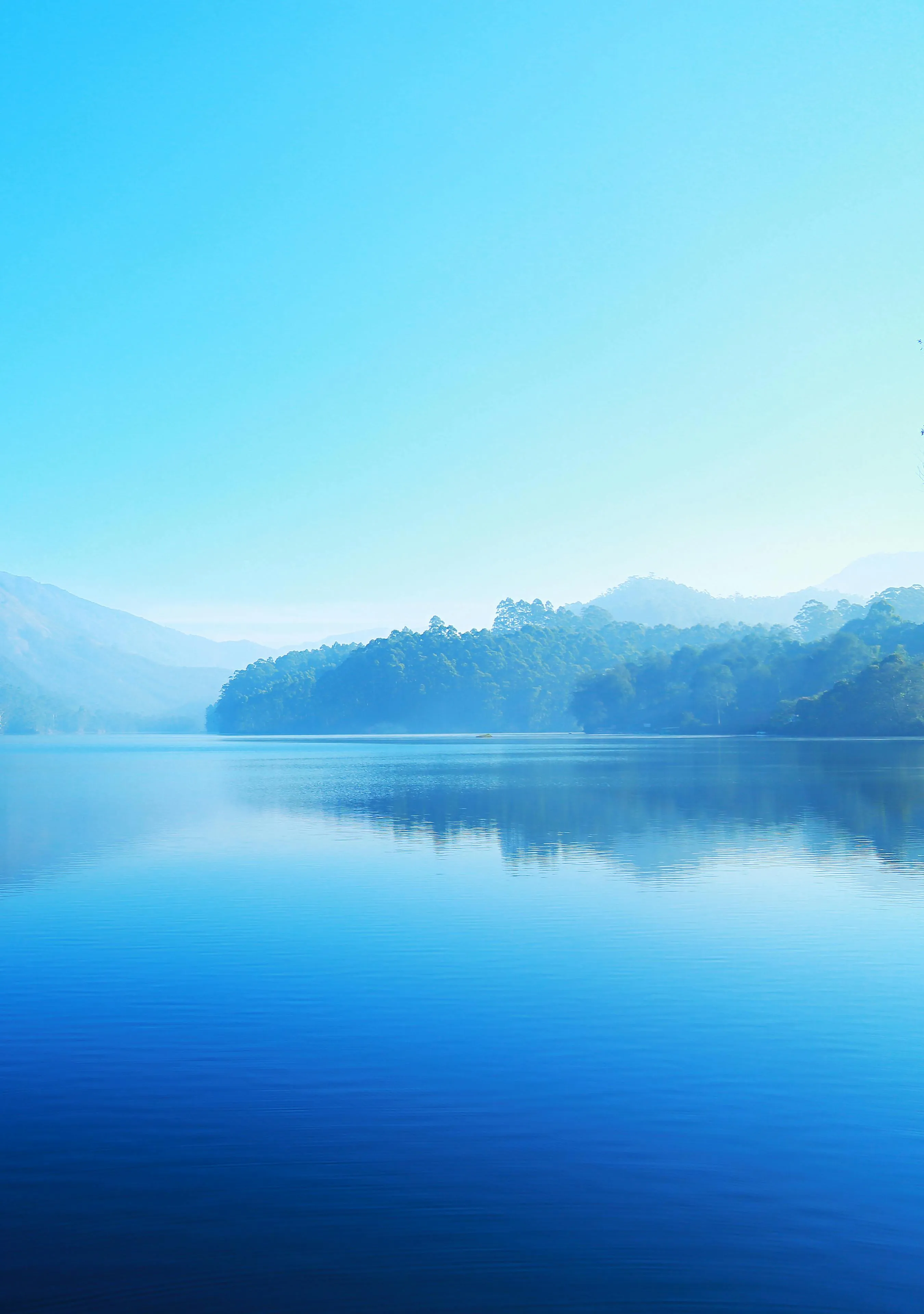 Calm Mountain Lake Reflecting Clouds and Blue Sky Image