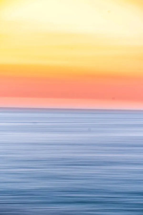 Calm Ocean Horizon with Soft Pastel Sunset Colors Wallpaper