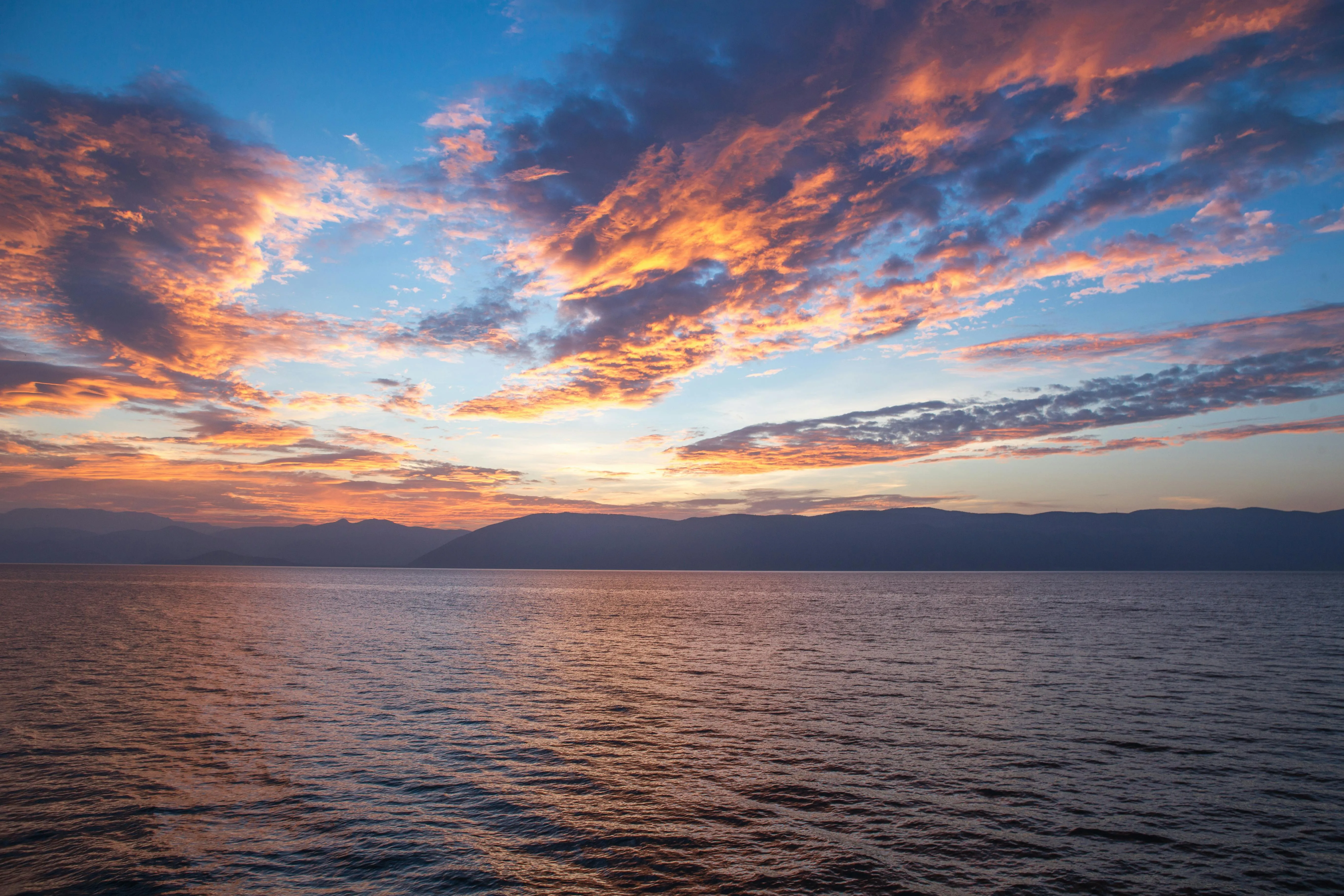 Calm Ocean Waters with Dramatic Evening Sky Clouds Image