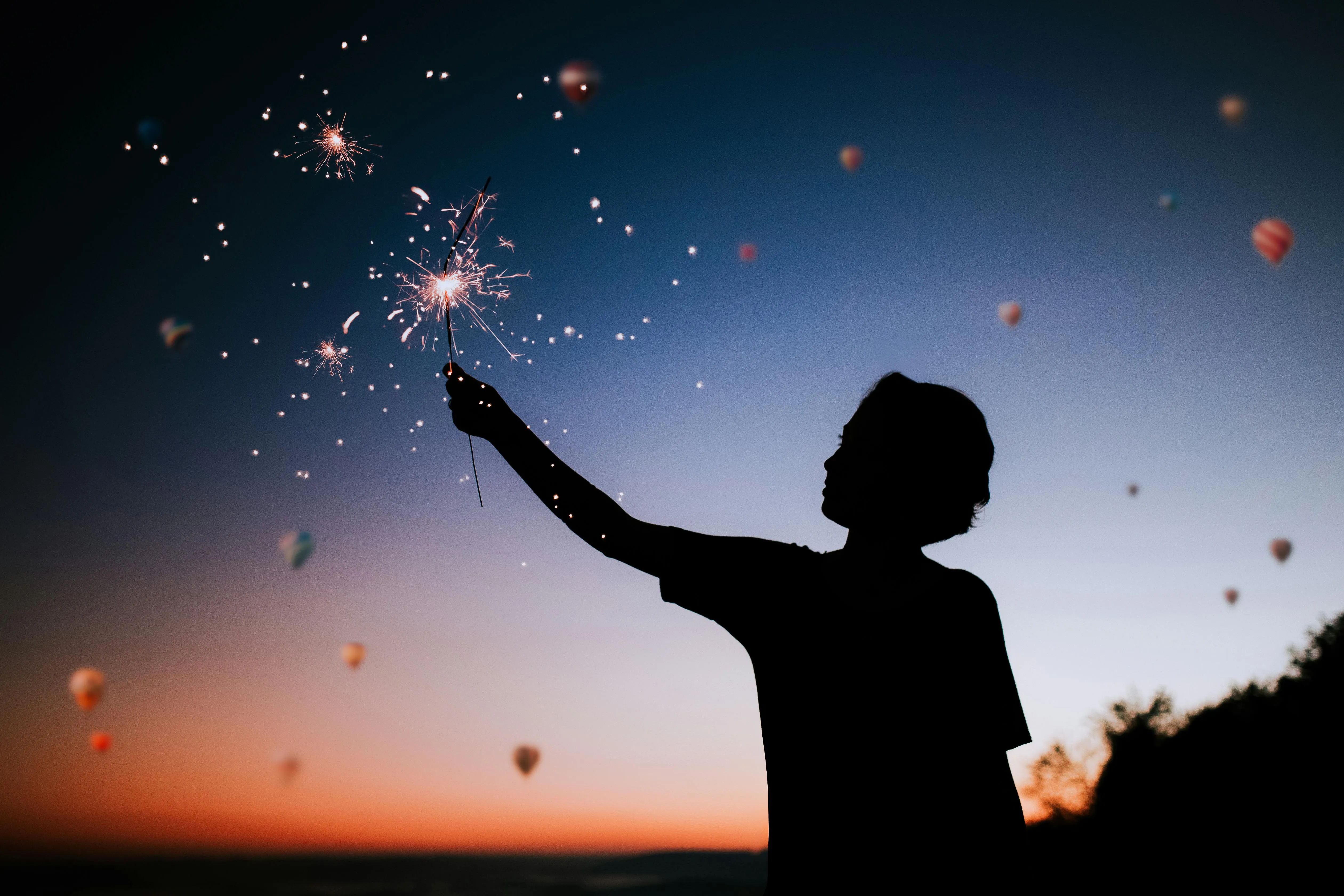 Child Enjoying Night Sky with Sparkling Fireworks Above