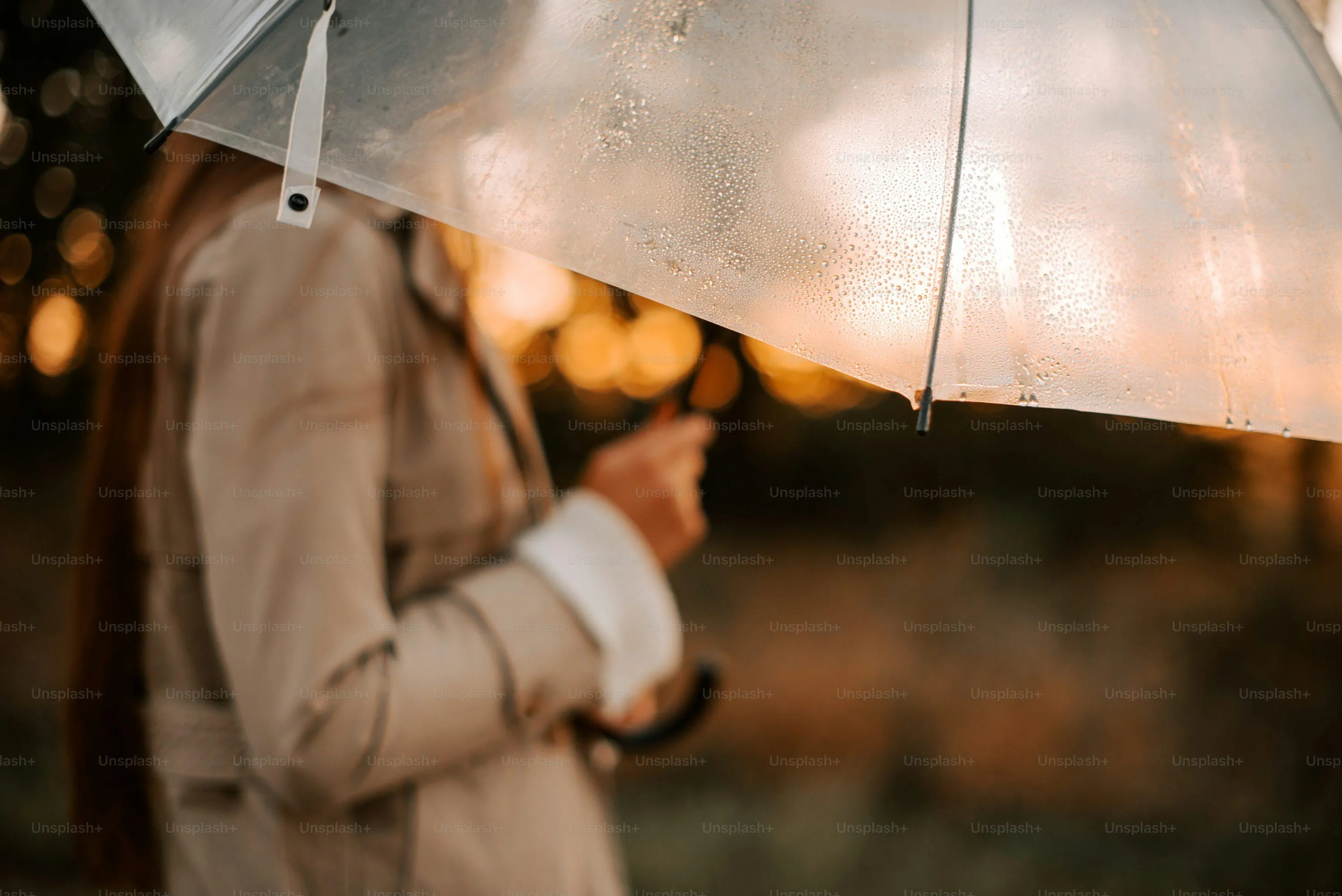 Child in Raincoat Looking Up While Holding Umbrella