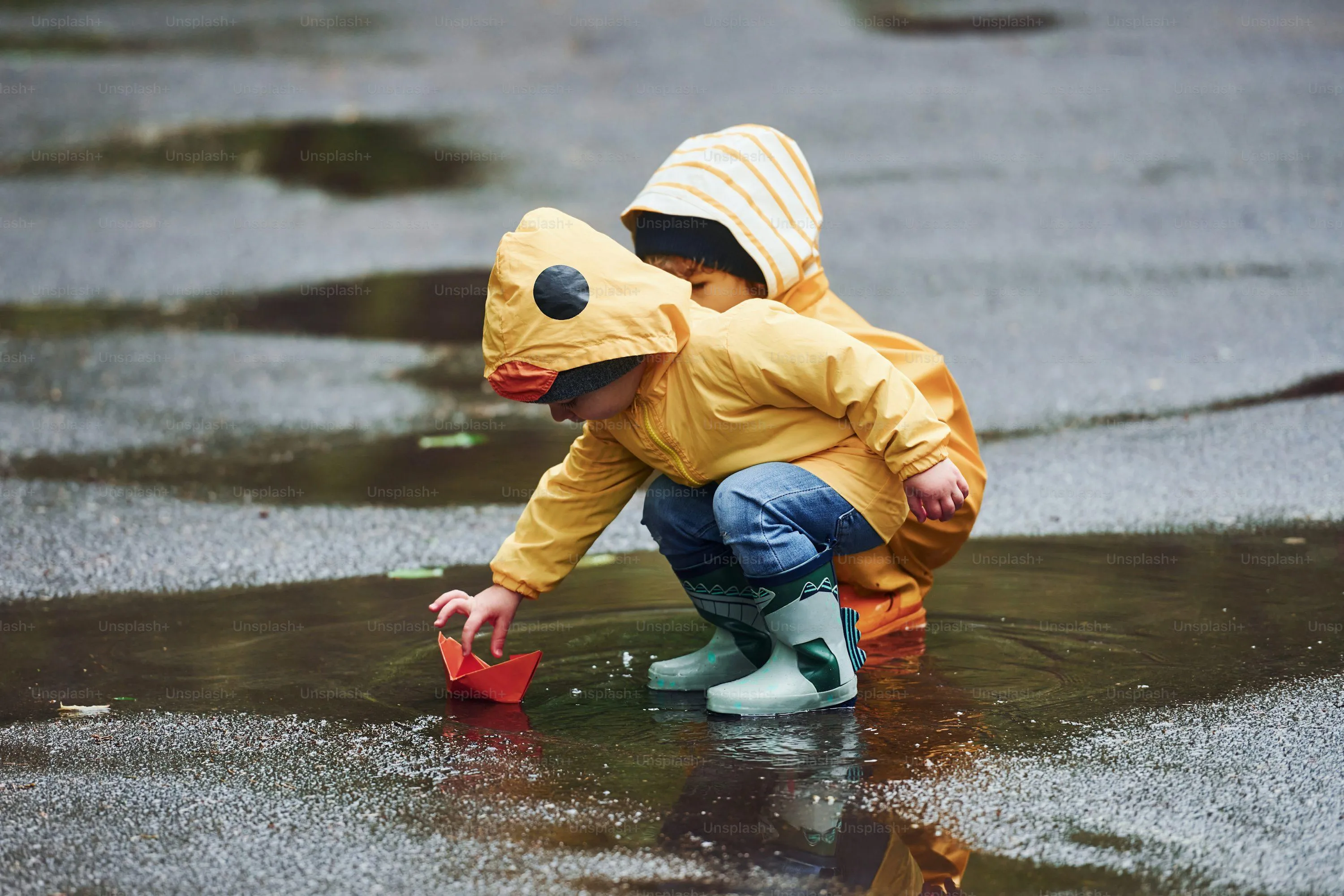 Child in Yellow Raincoat Playing Near Puddle Wallpaper