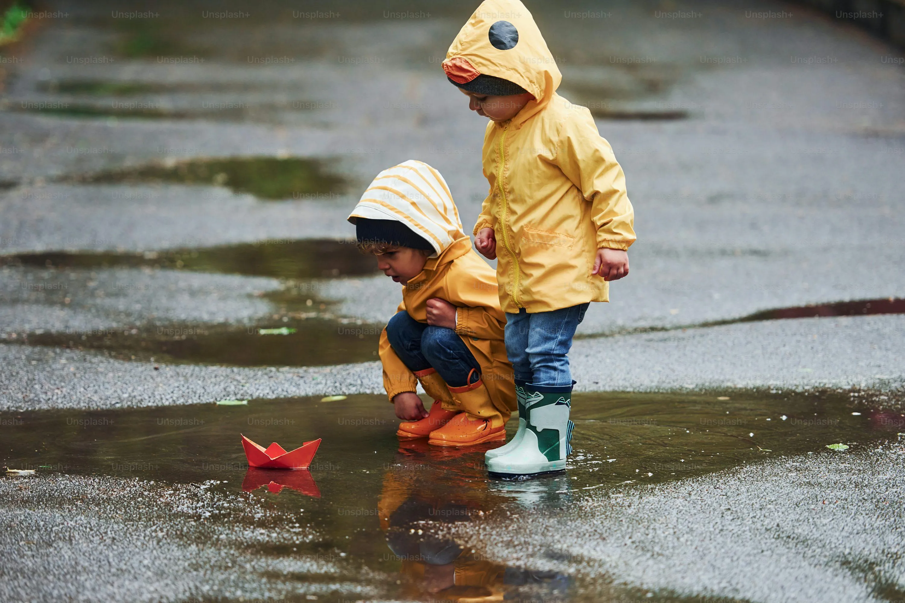 Child in Yellow Raincoat Standing in Puddle Wallpaper