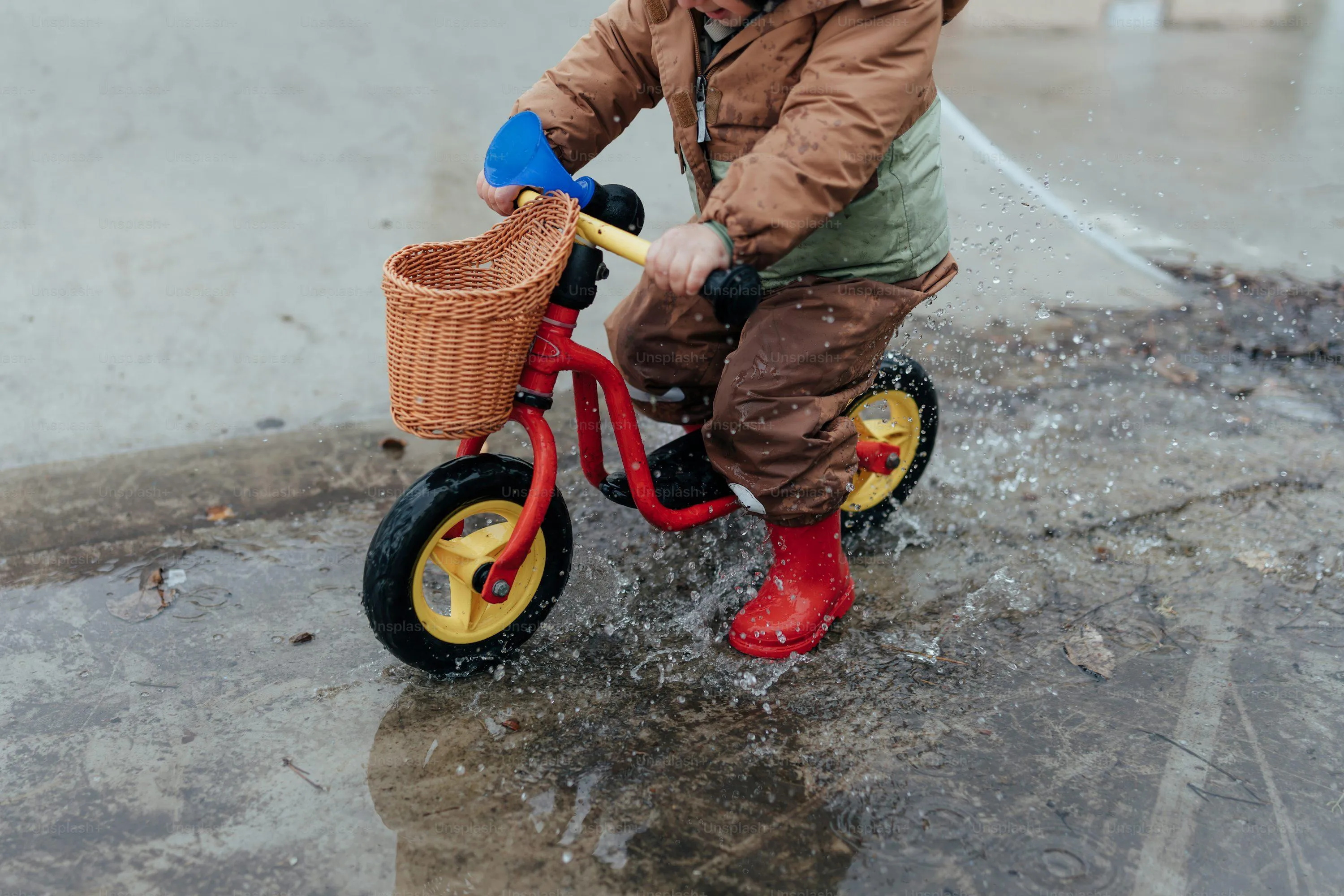 Child Riding Tricycle in Wet Rainy Weather Wallpaper