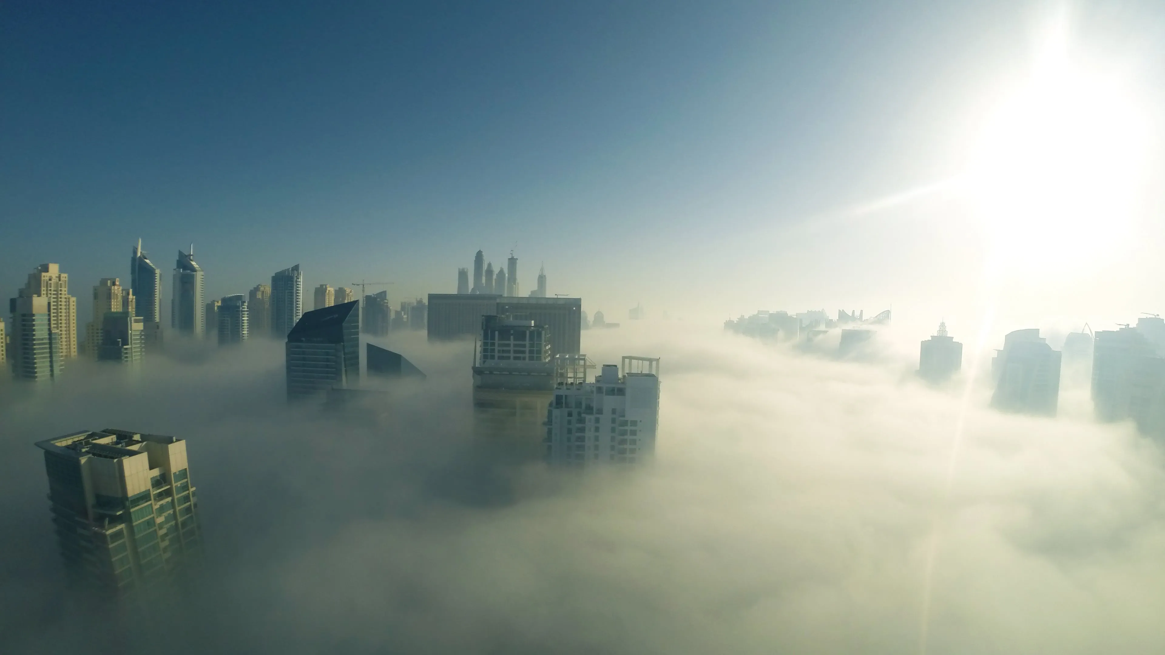 City Buildings Emerging Through Thick Foggy Clouds Image