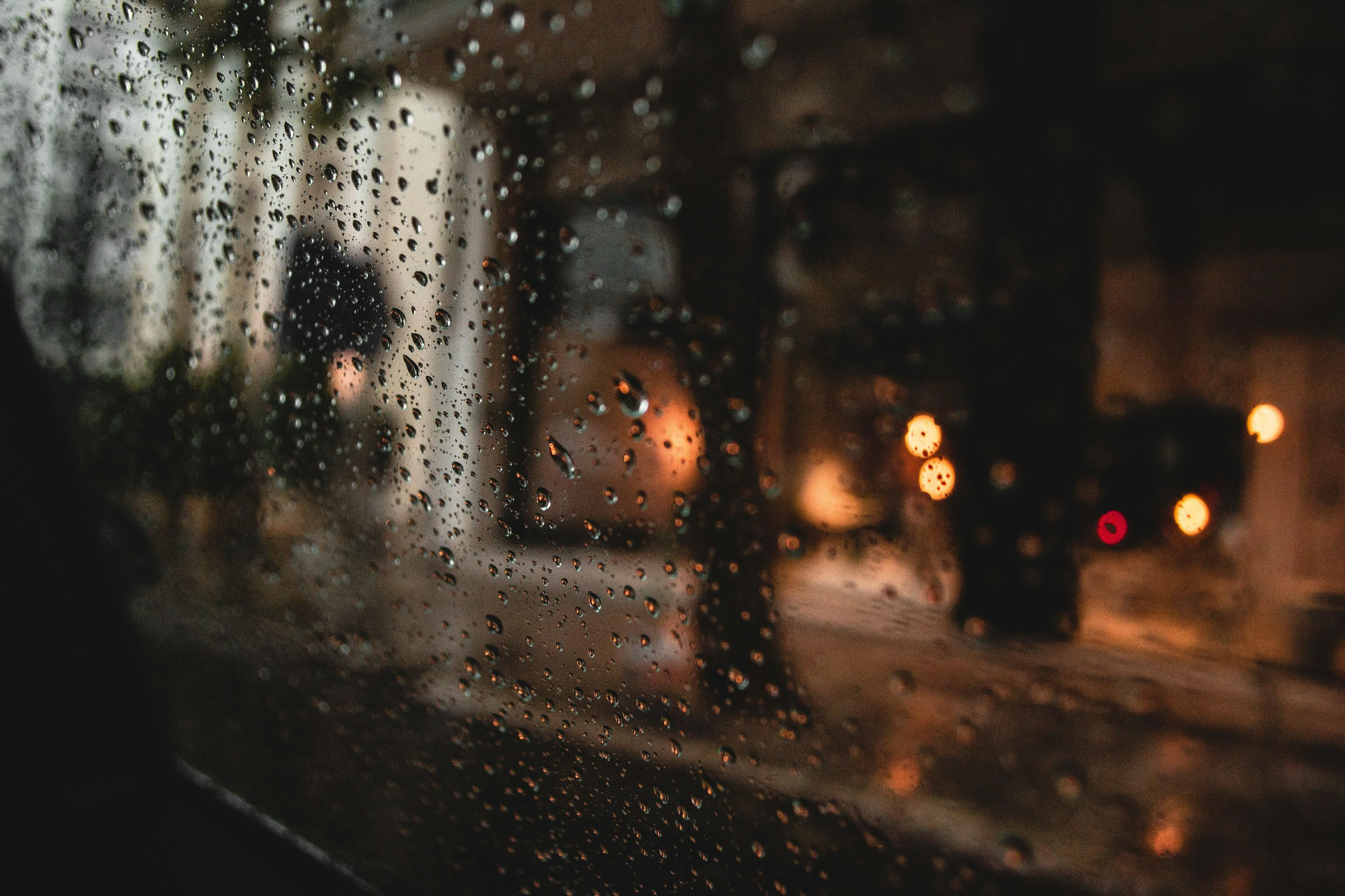 City Lights Reflected on Wet Pavement in Rainy Weather