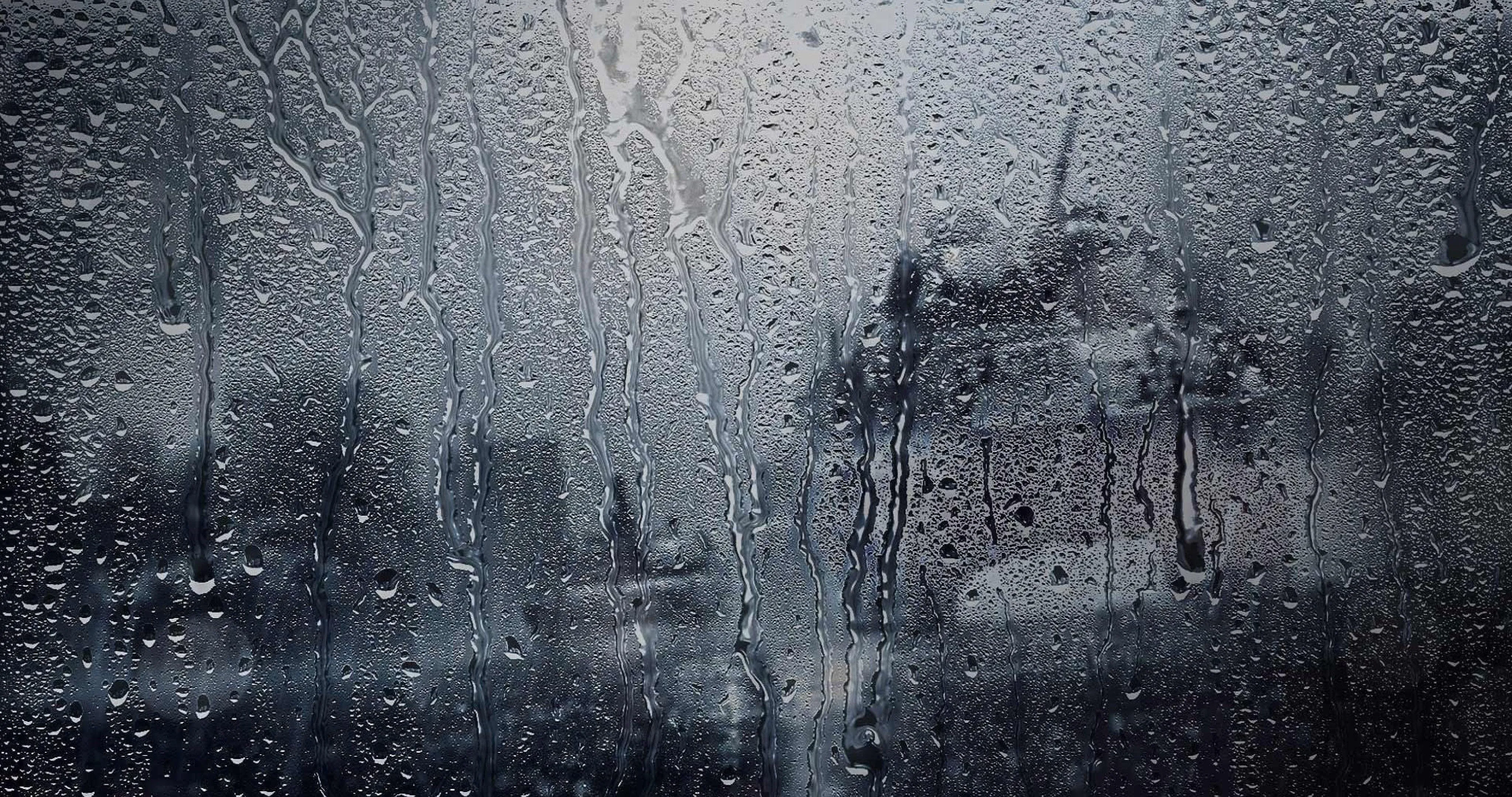 City Rainfall Seen Through Glass Window on Gloomy Evening