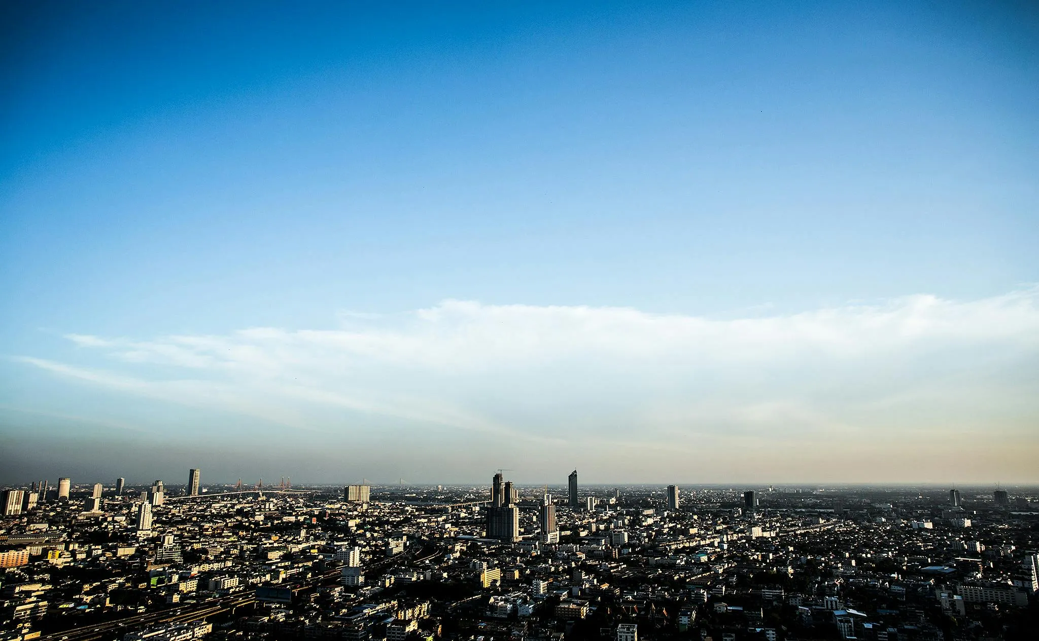 City Skyline Under a Clear Blue Sky with Scattered Clouds