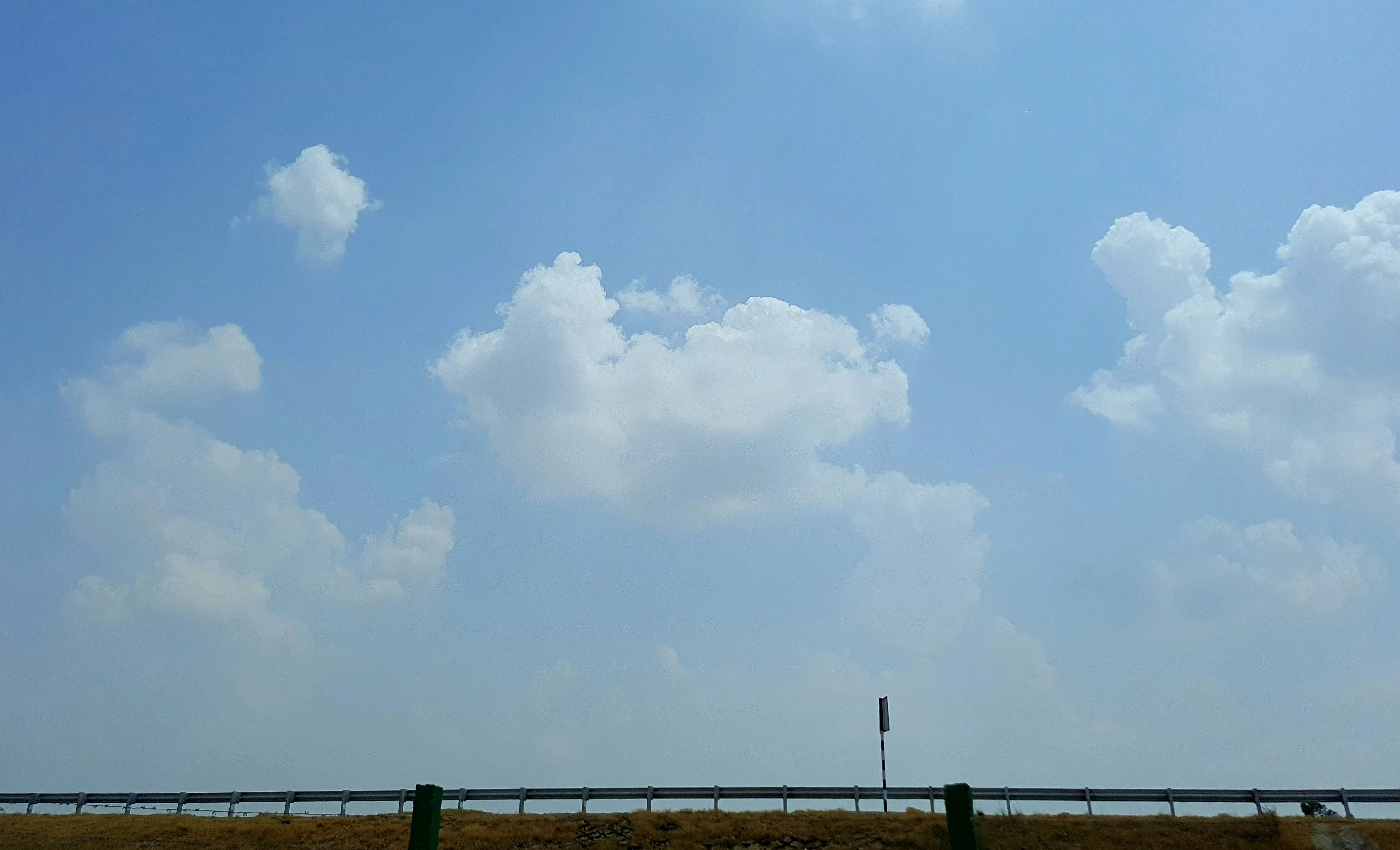 Clear Blue Sky with a Few White Clouds Over Flat Landscape