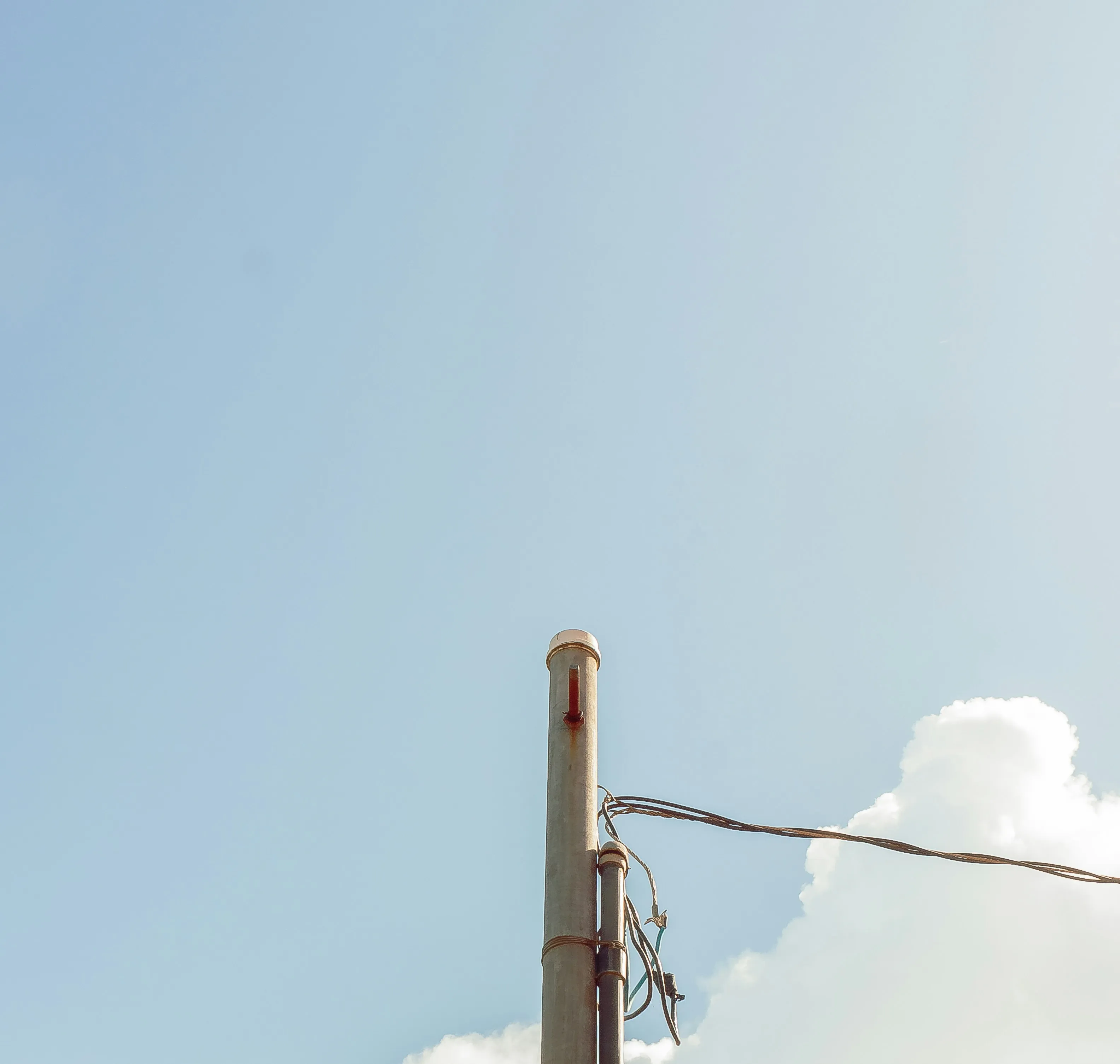 Clear Blue Sky with a Single Cloud Near Utility Pole