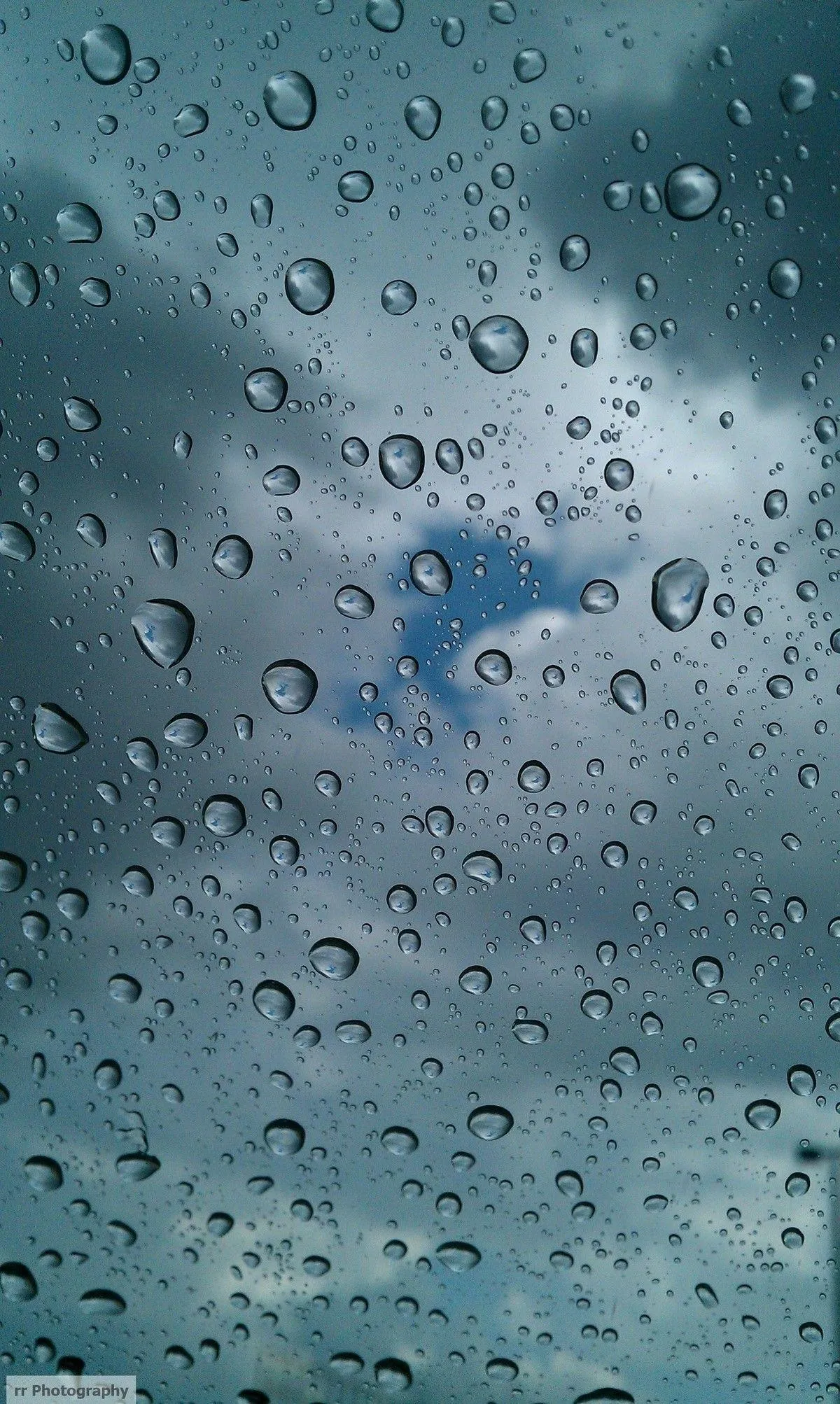 Close Up of Raindrops on Window with Blue Background
