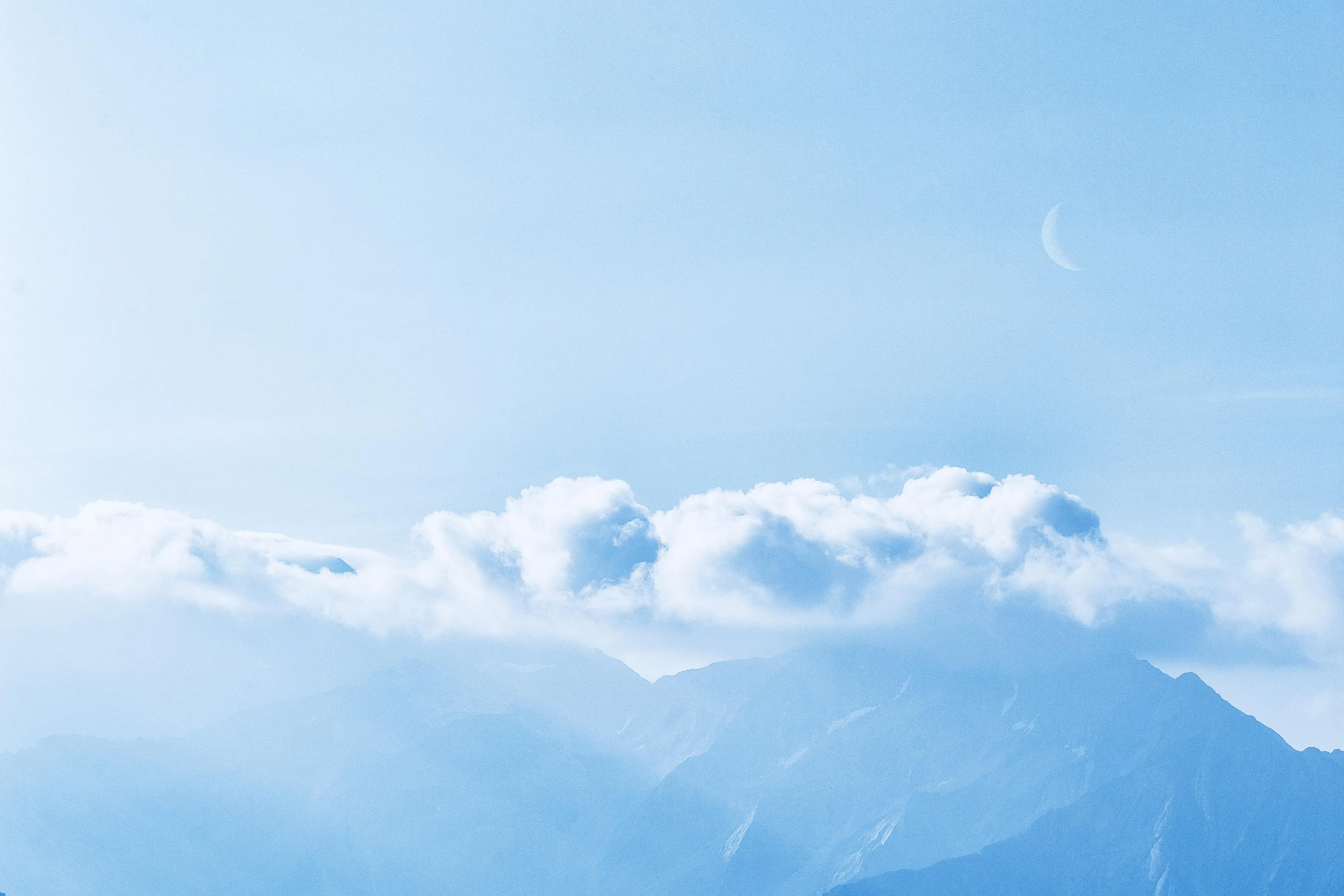 Close Up of Snow Covered Mountains Under Cloudy Sky