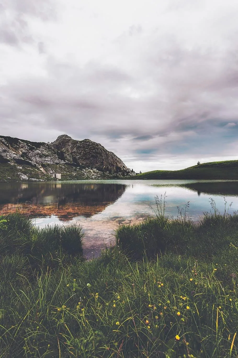 Cloudy Lake Shore with Distant Mountains and Reflections