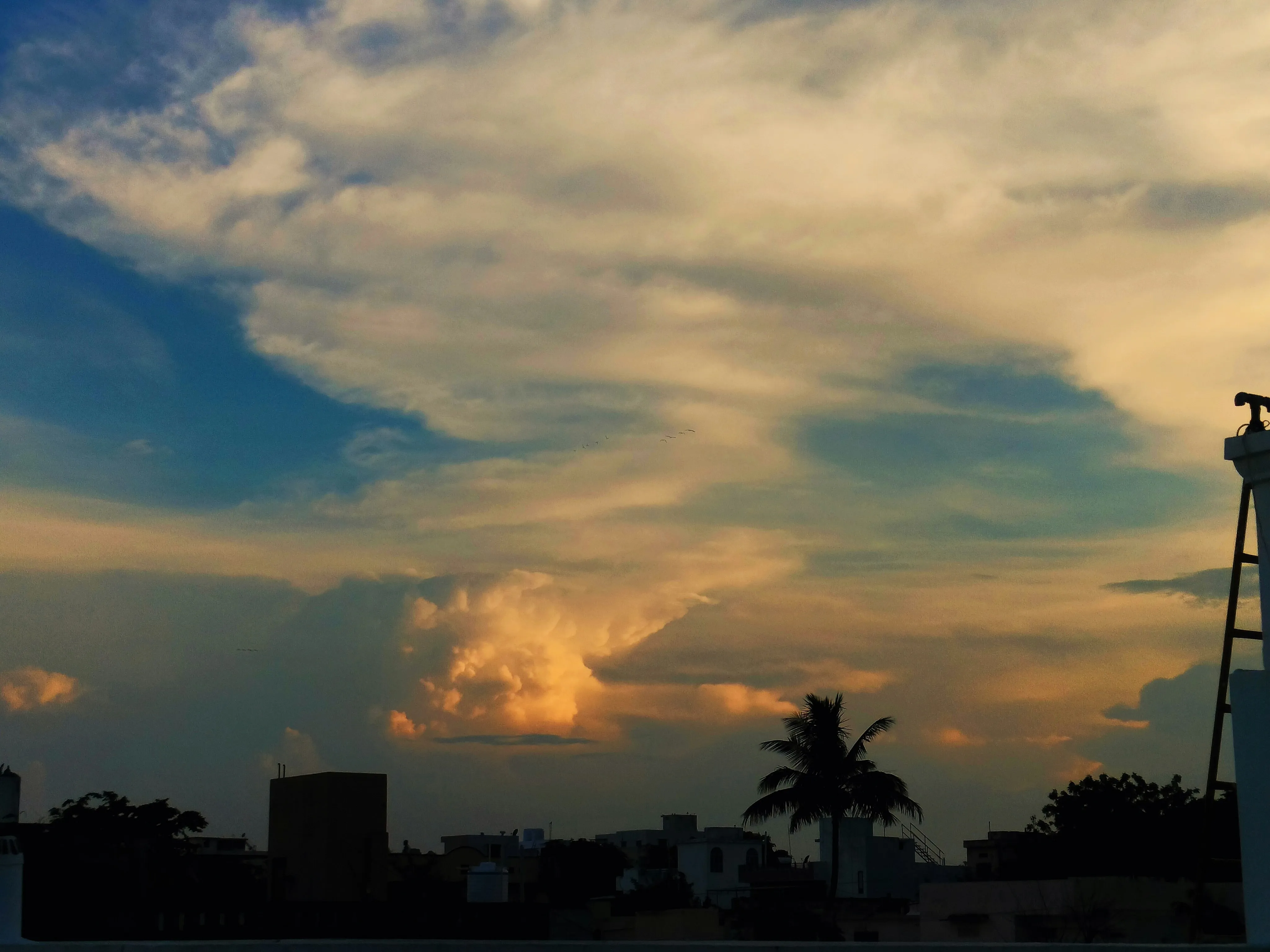 Colorful Clouds Glowing Above City Skyline at Sunset