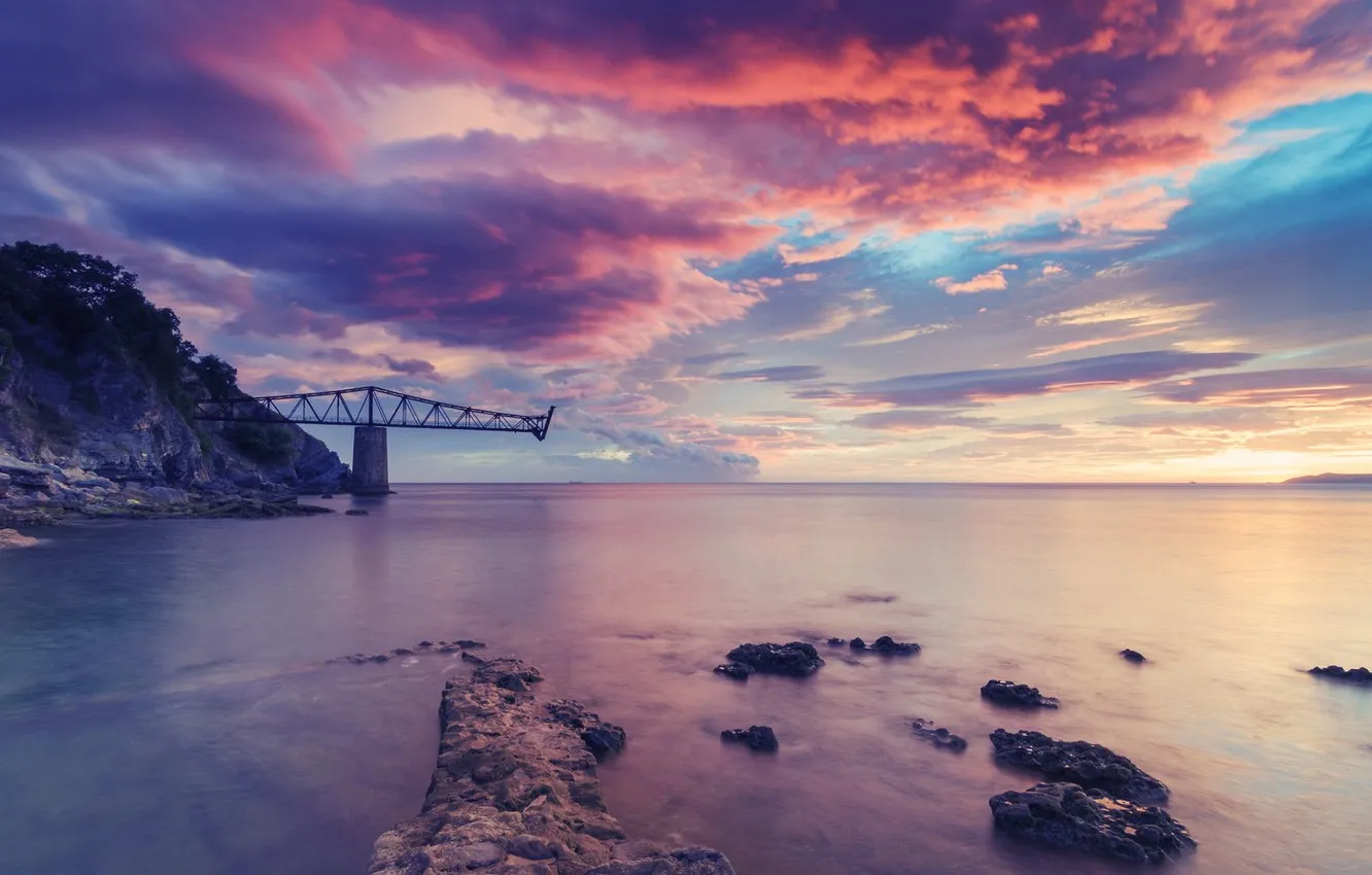Colorful Sunset Over Rocky Shore with Pink Clouds Image