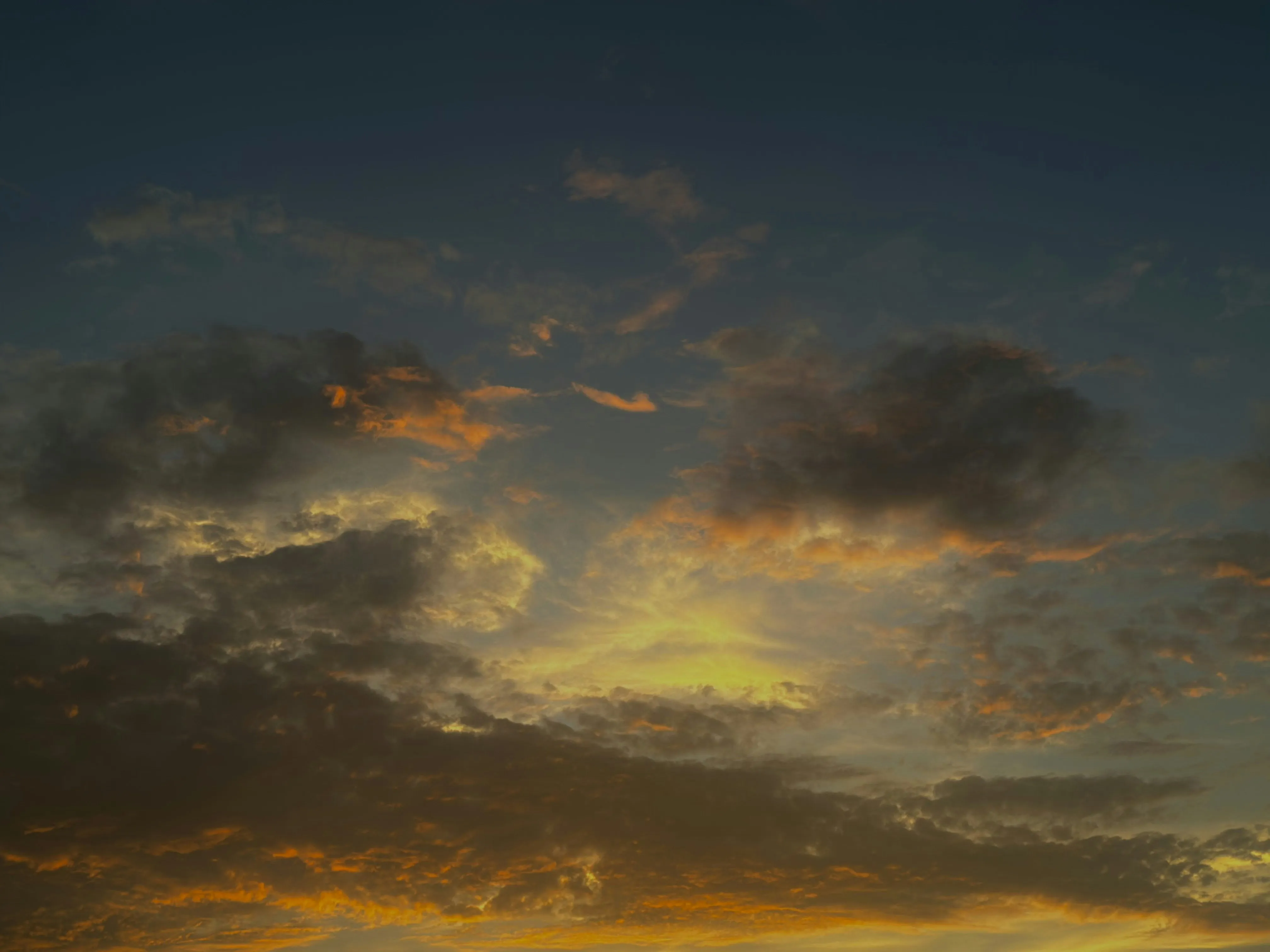Colorful Sunset with Scattered Clouds Over Rural Land