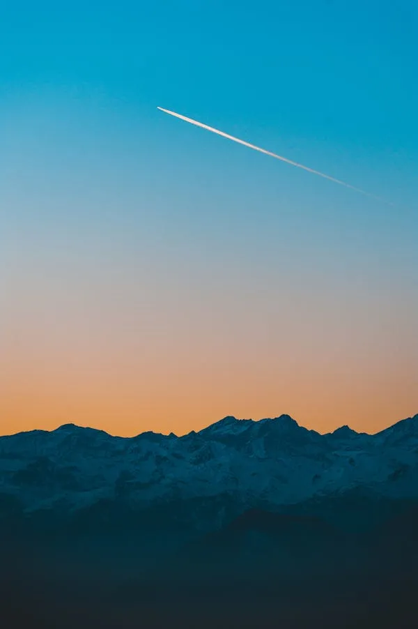 Contrail Streak in Twilight Sky Over Mountain View Wallpaper