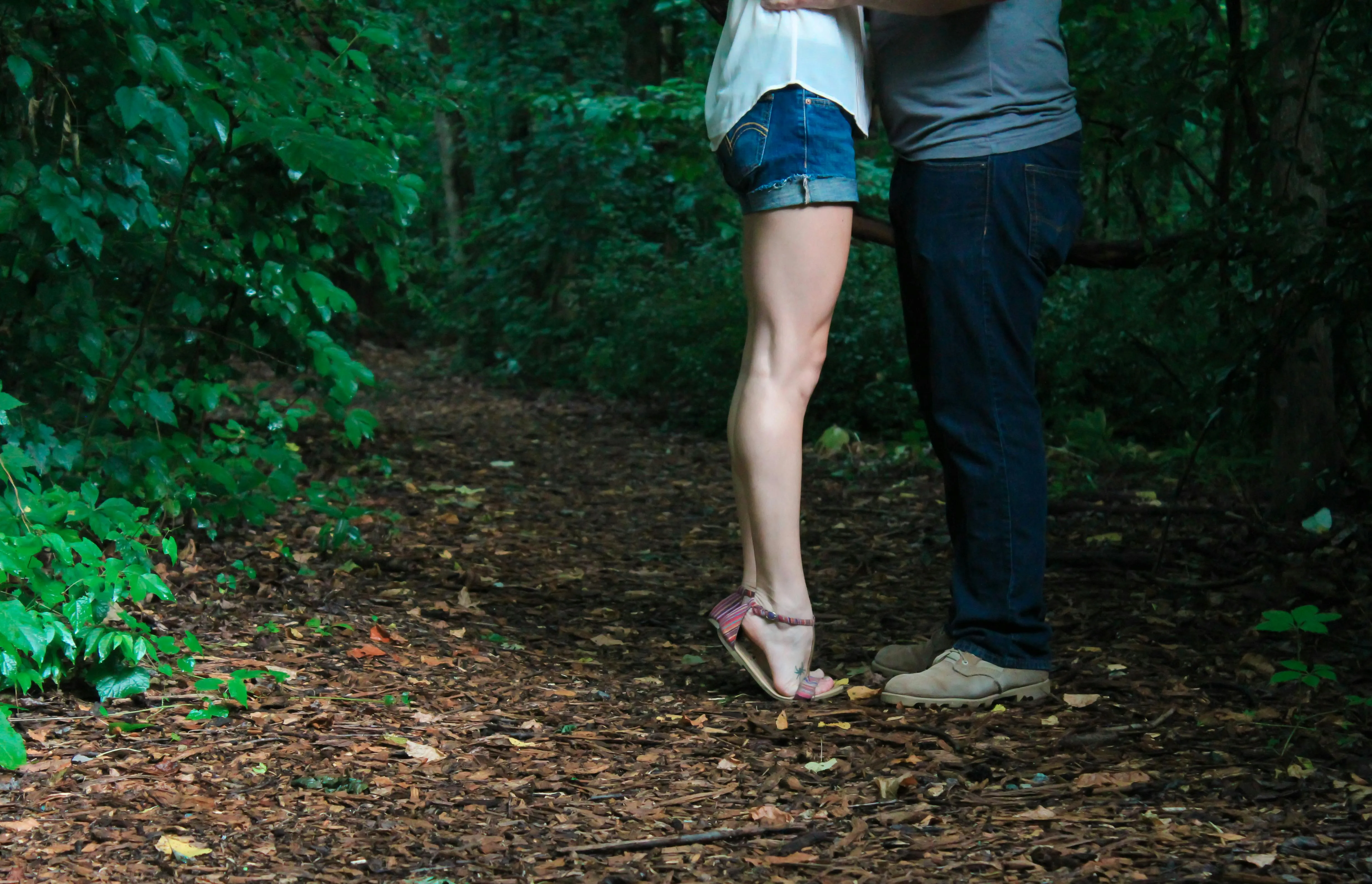 Couple Standing on a Forest Path Surrounded by Green Foliage