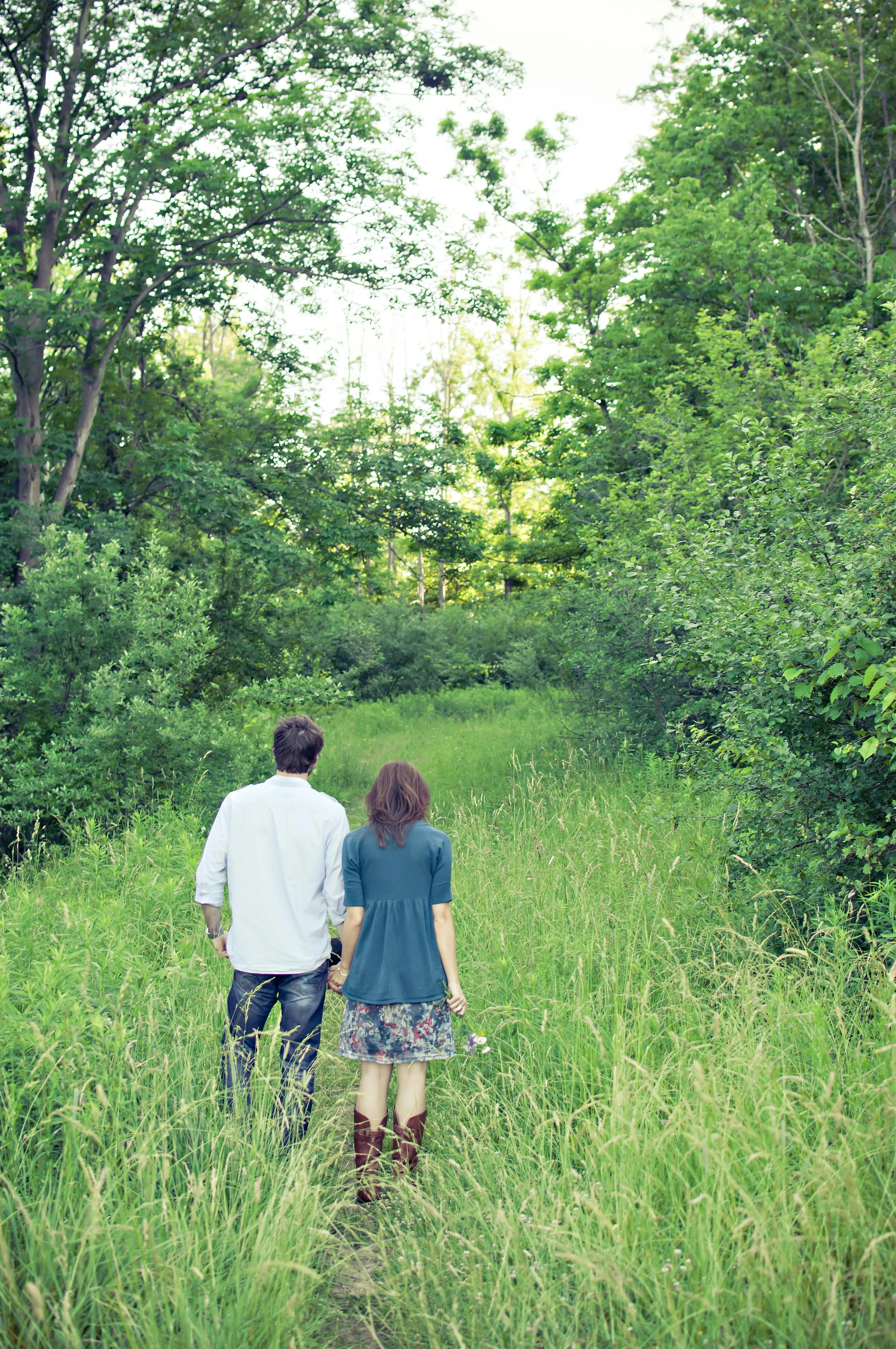 Couples Walking on a Forest Path During the Summer Greenery