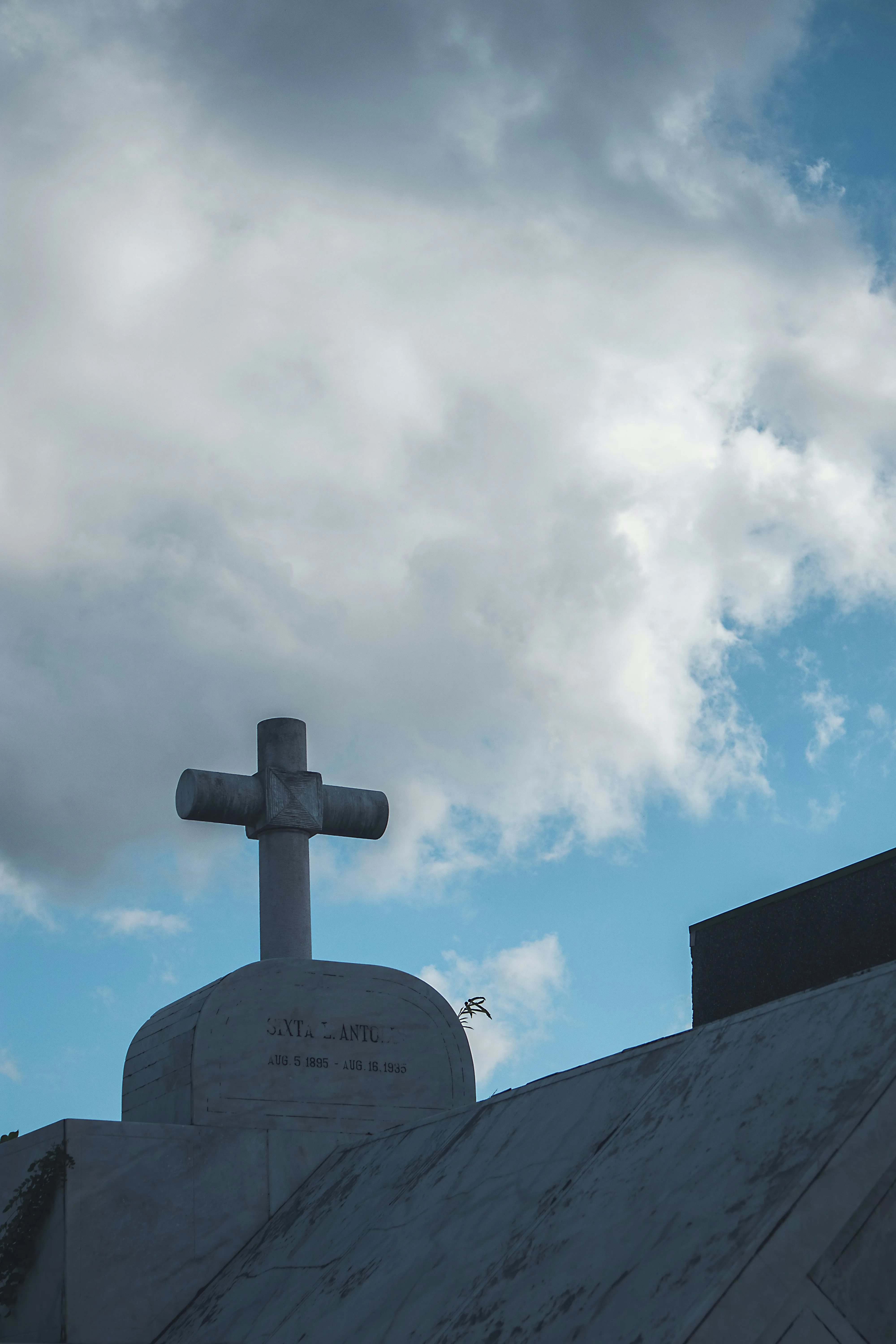 Cross Monument Silhouette Against Blue Sky with Clouds