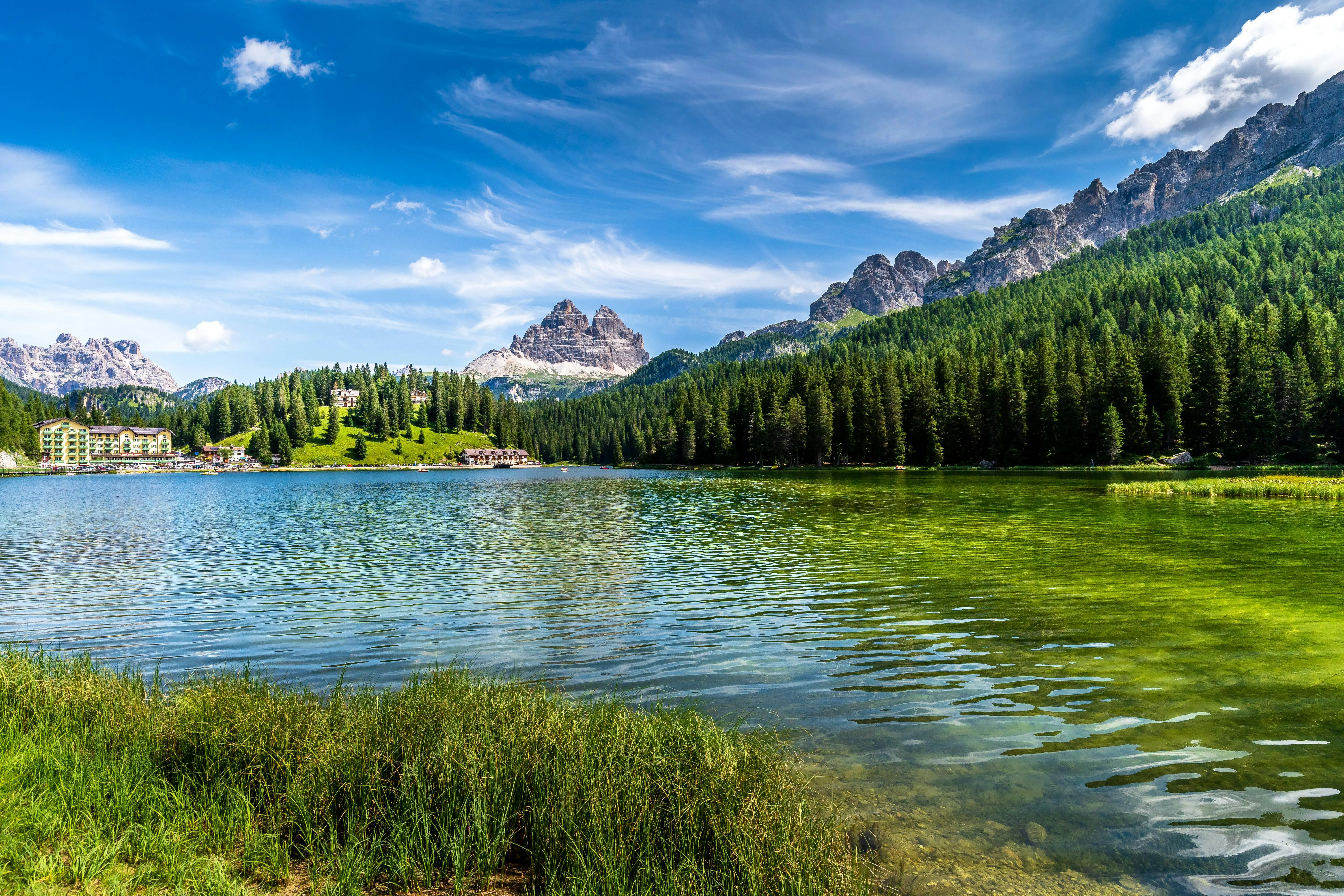 Crystal Clear Lake Reflecting Snowy Peaks and Forest Trees
