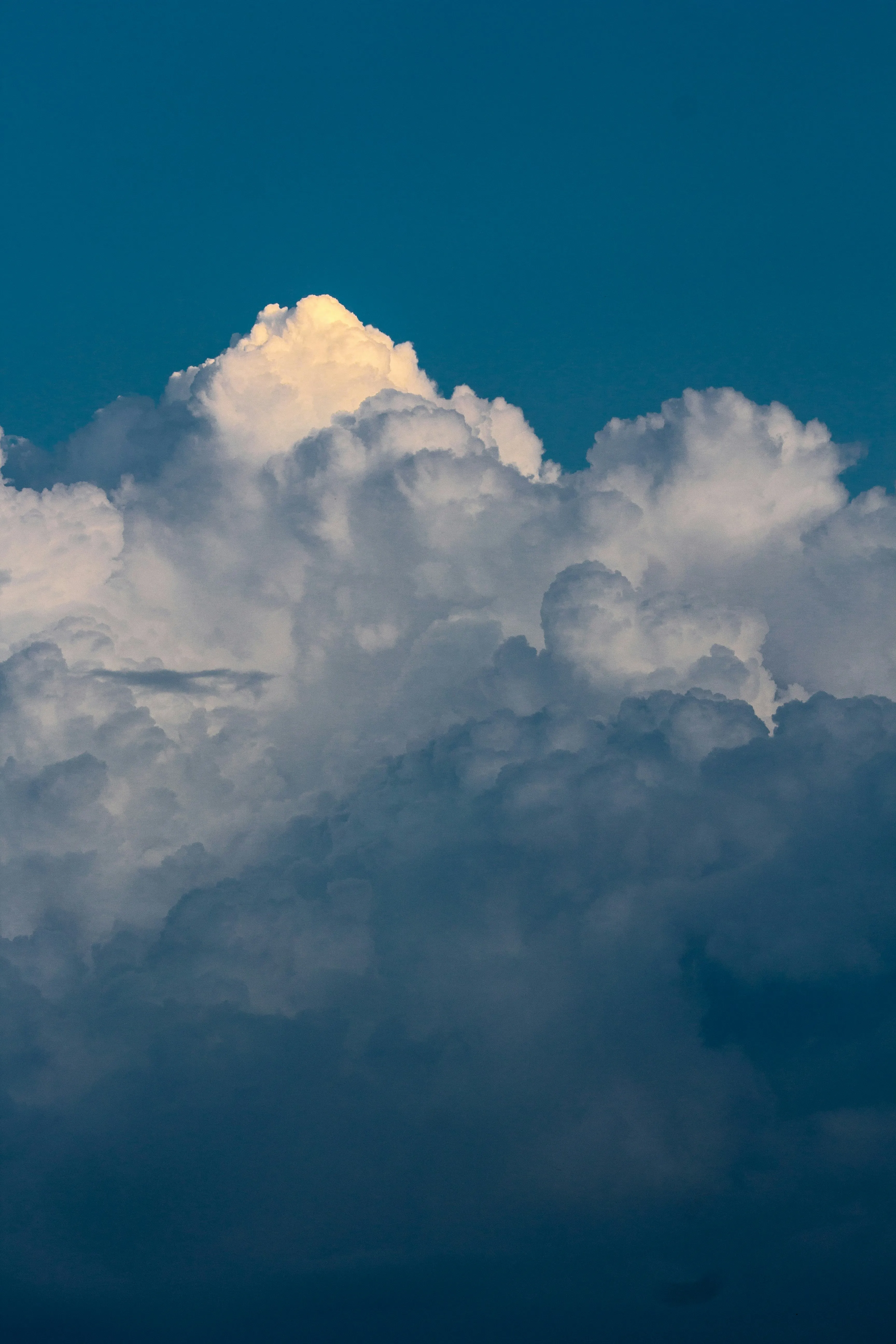 Dark Blue Sky with Tall White Clouds Rising Upward Image