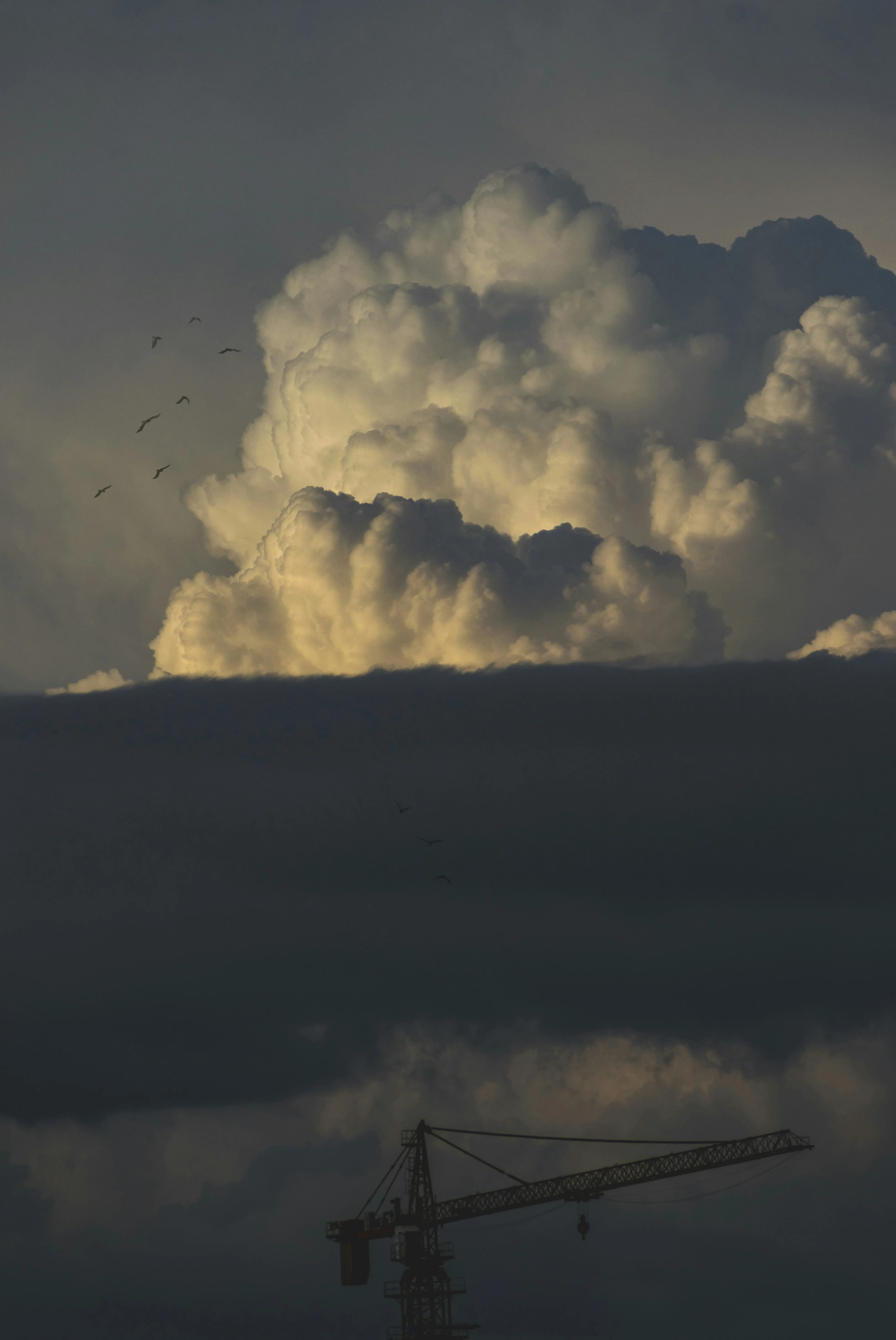 Dark Cloud Formation Over Construction Crane in Evening Light