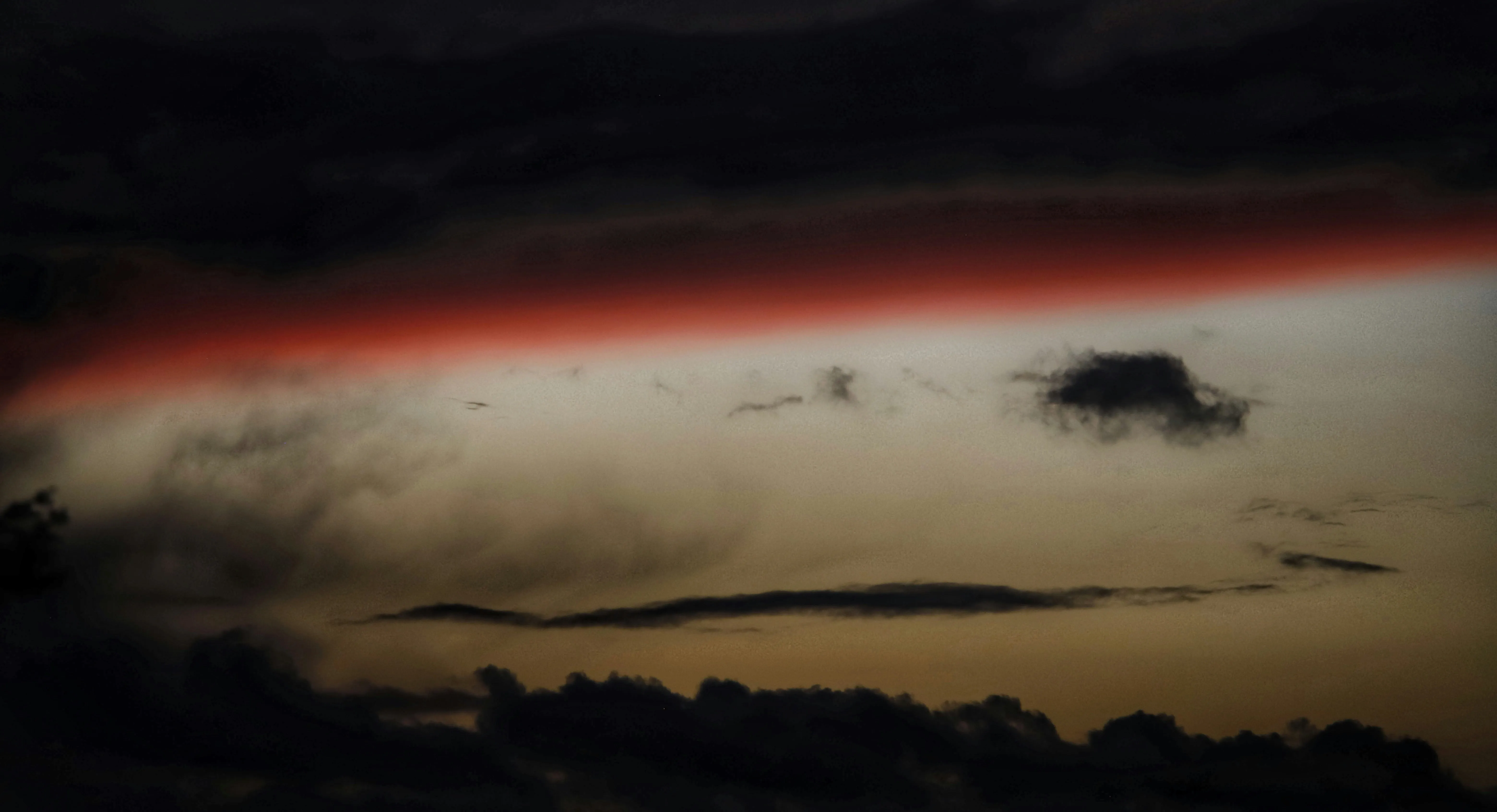 Dark Clouds and Fiery Sunset Over Quiet Landscape Horizon