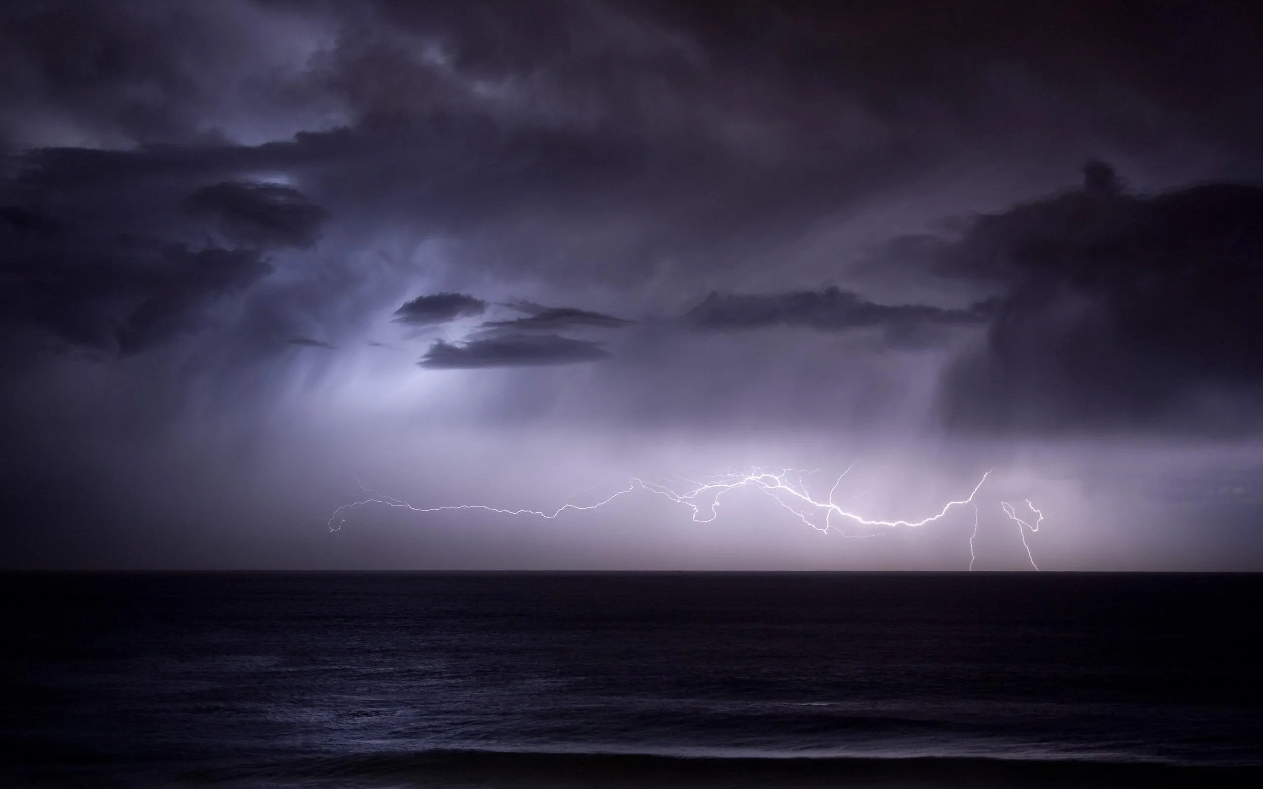 Dark Storm Clouds with Lightning Flash Over the Ocean