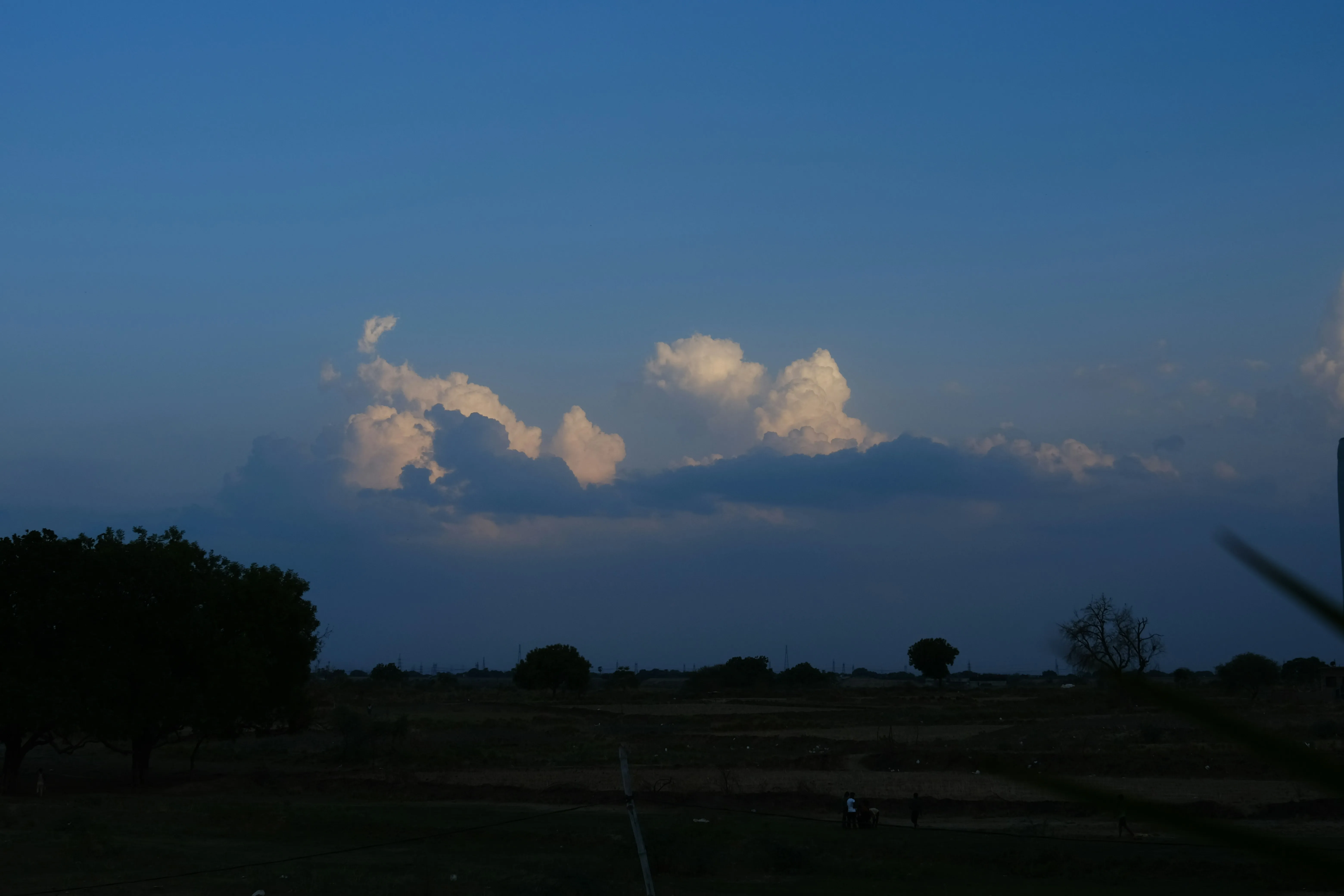 Darkening Sky with Small Cloud Formations Over Landscape