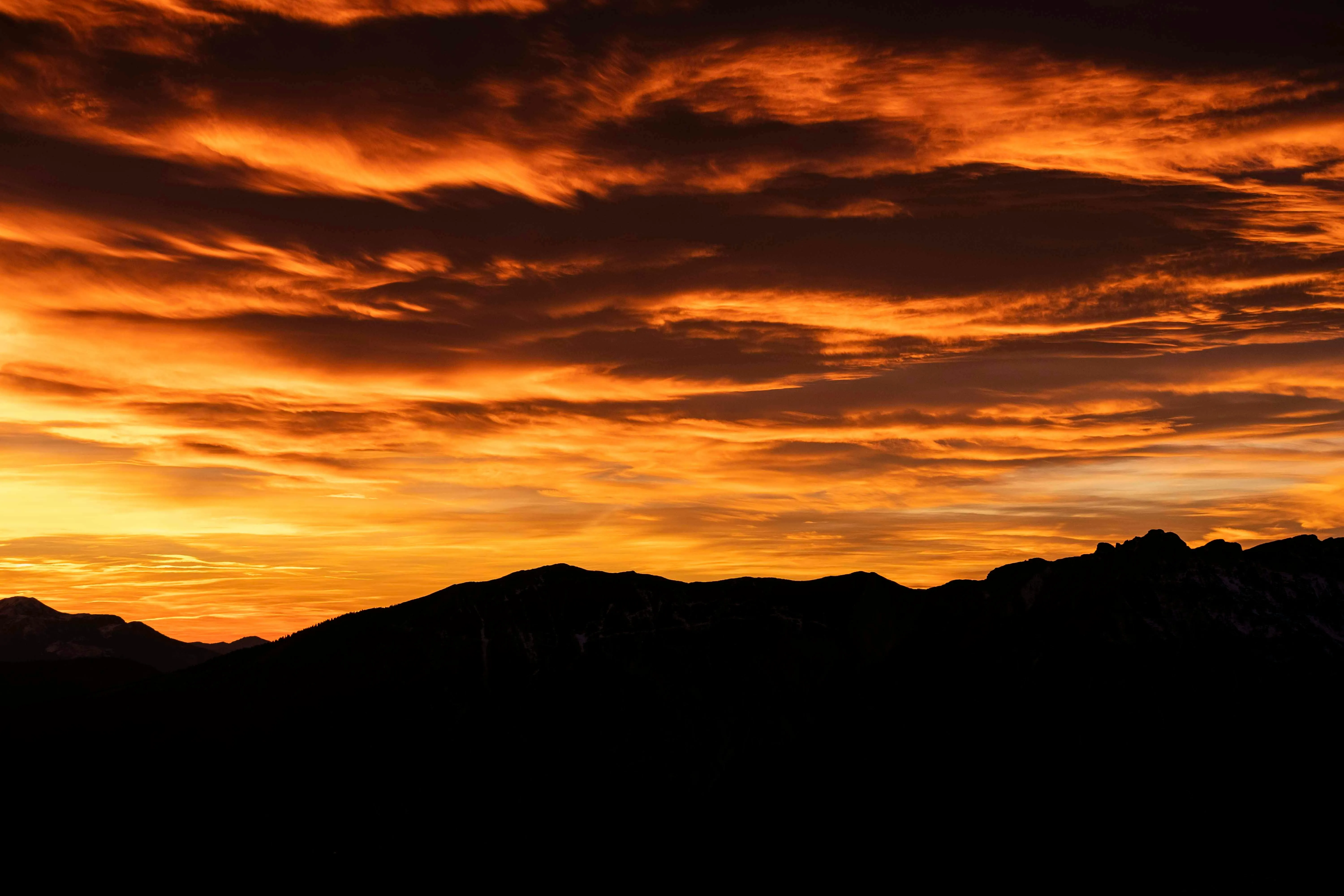Deep Orange Sunset Behind Silhouette of Hills Wallpaper