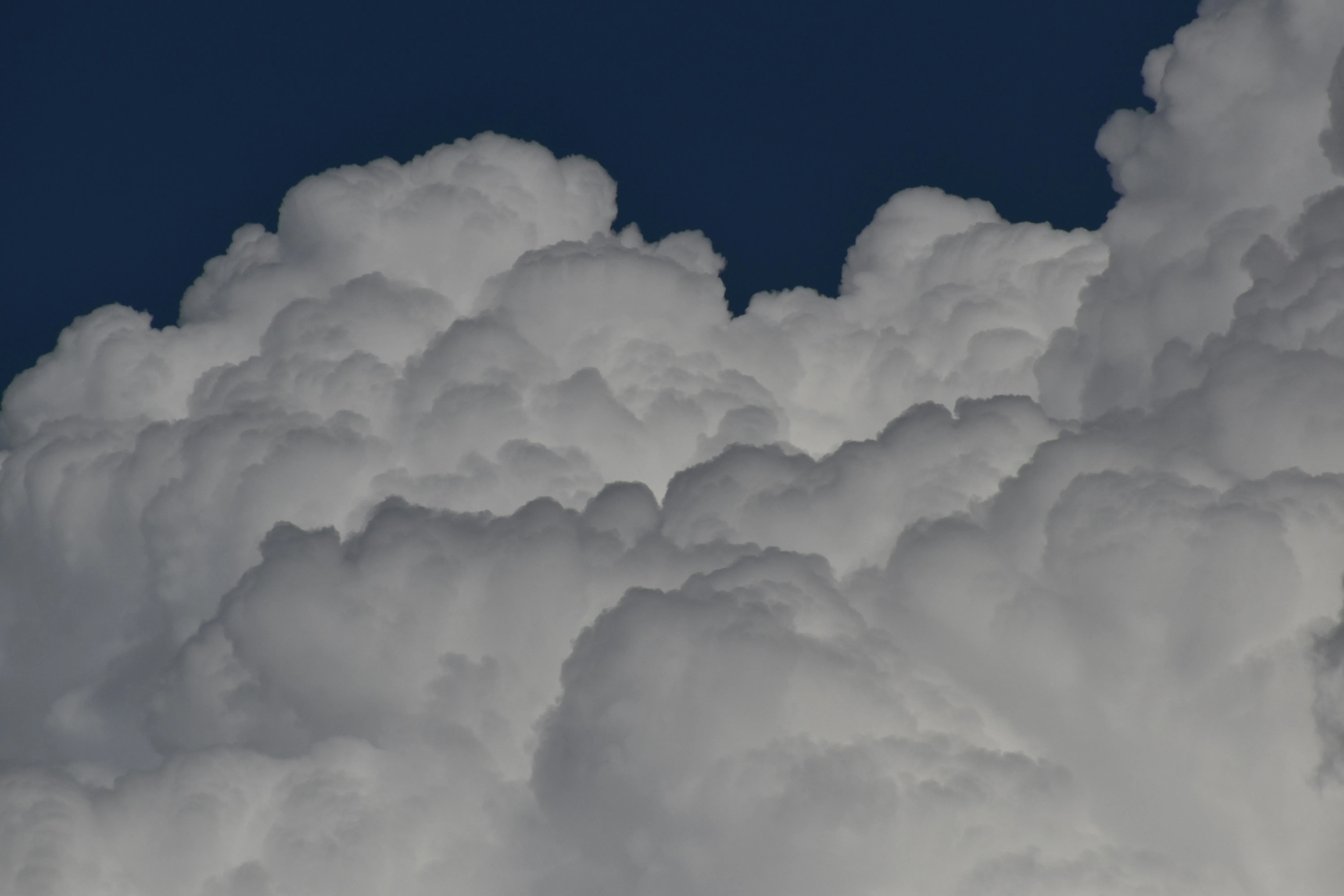 Dense Clouds Building Up Against a Deep Blue Sky Wallpaper