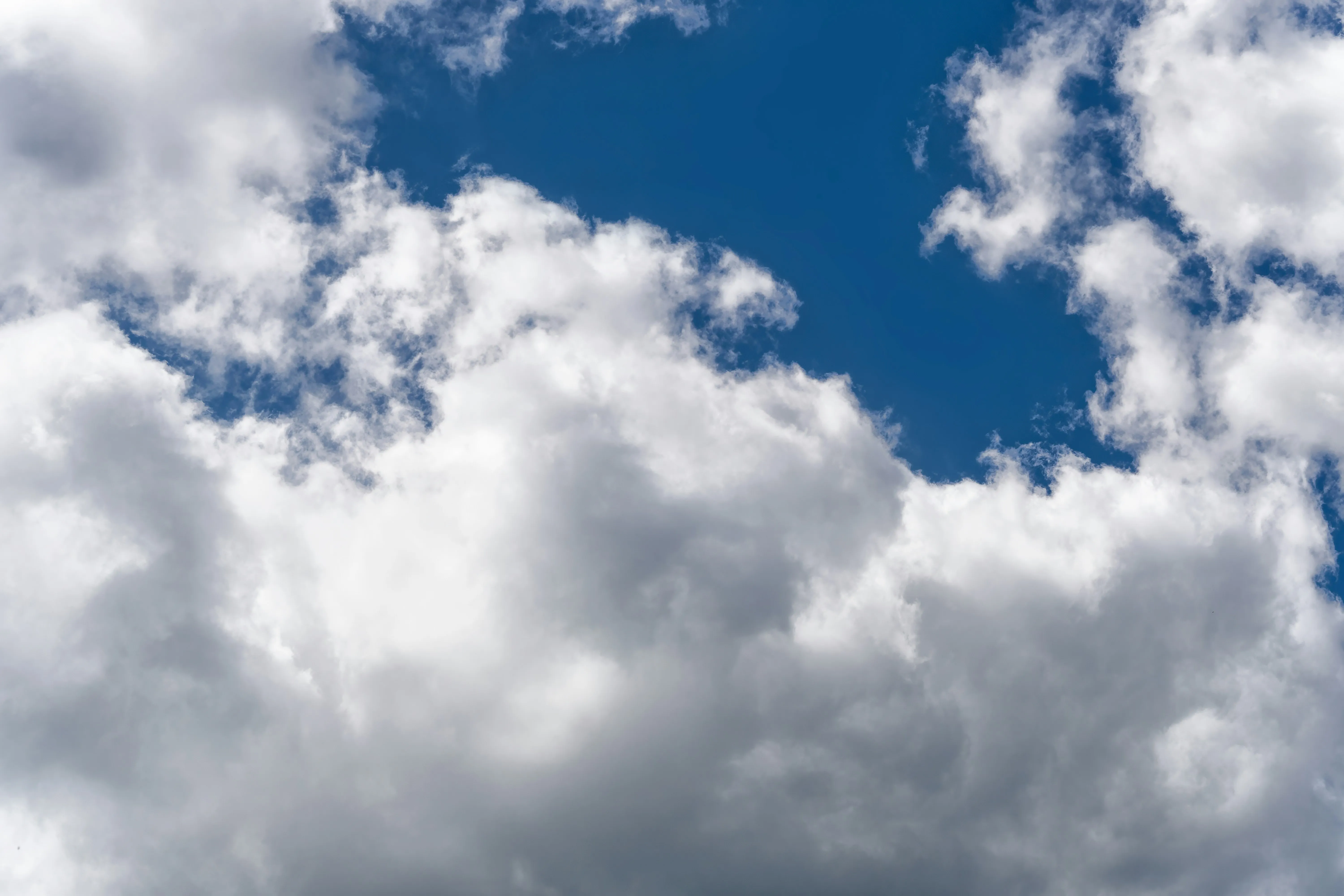 Dense White Clouds Floating in a Vibrant Blue Sky Wallpaper
