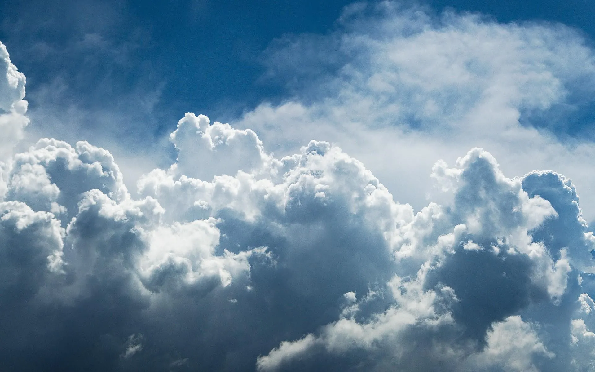 Dramatic Clouds Over Mountain Peaks with Blue Sky Image