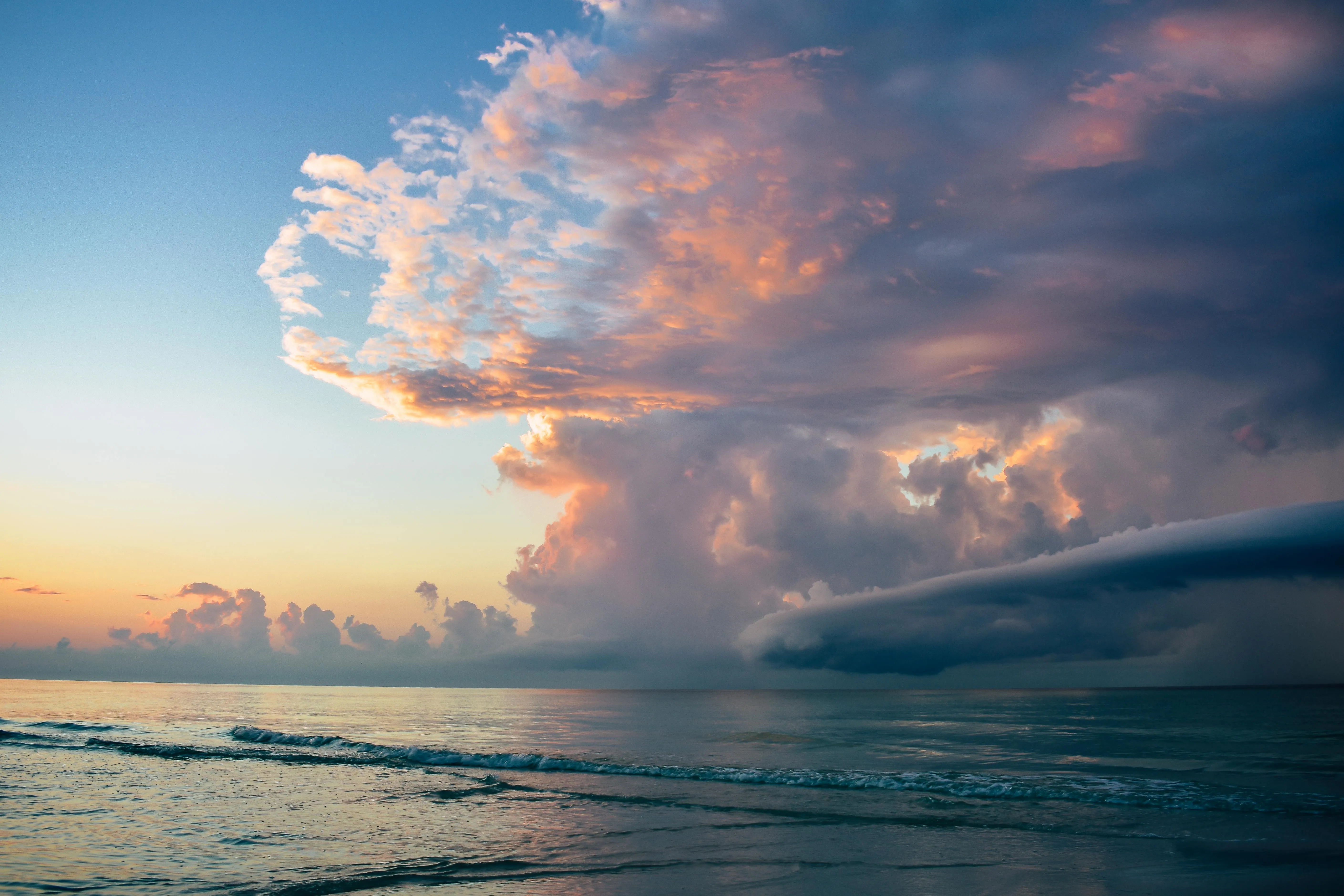 Dramatic Pink Cloud Formation Over Calm Ocean Horizon