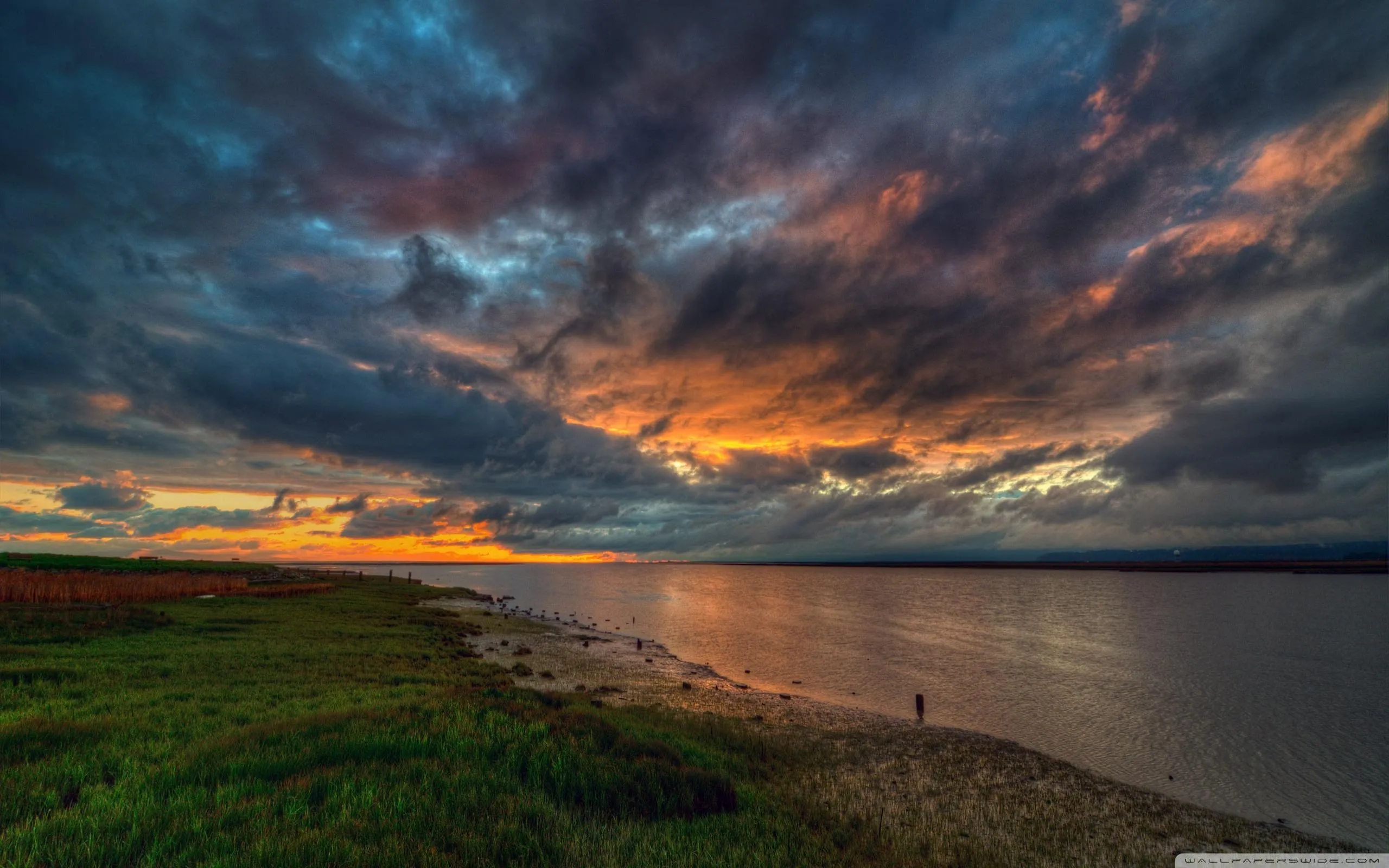 Dramatic Sunset Sky with Dark Orange Clouds Over Landscape