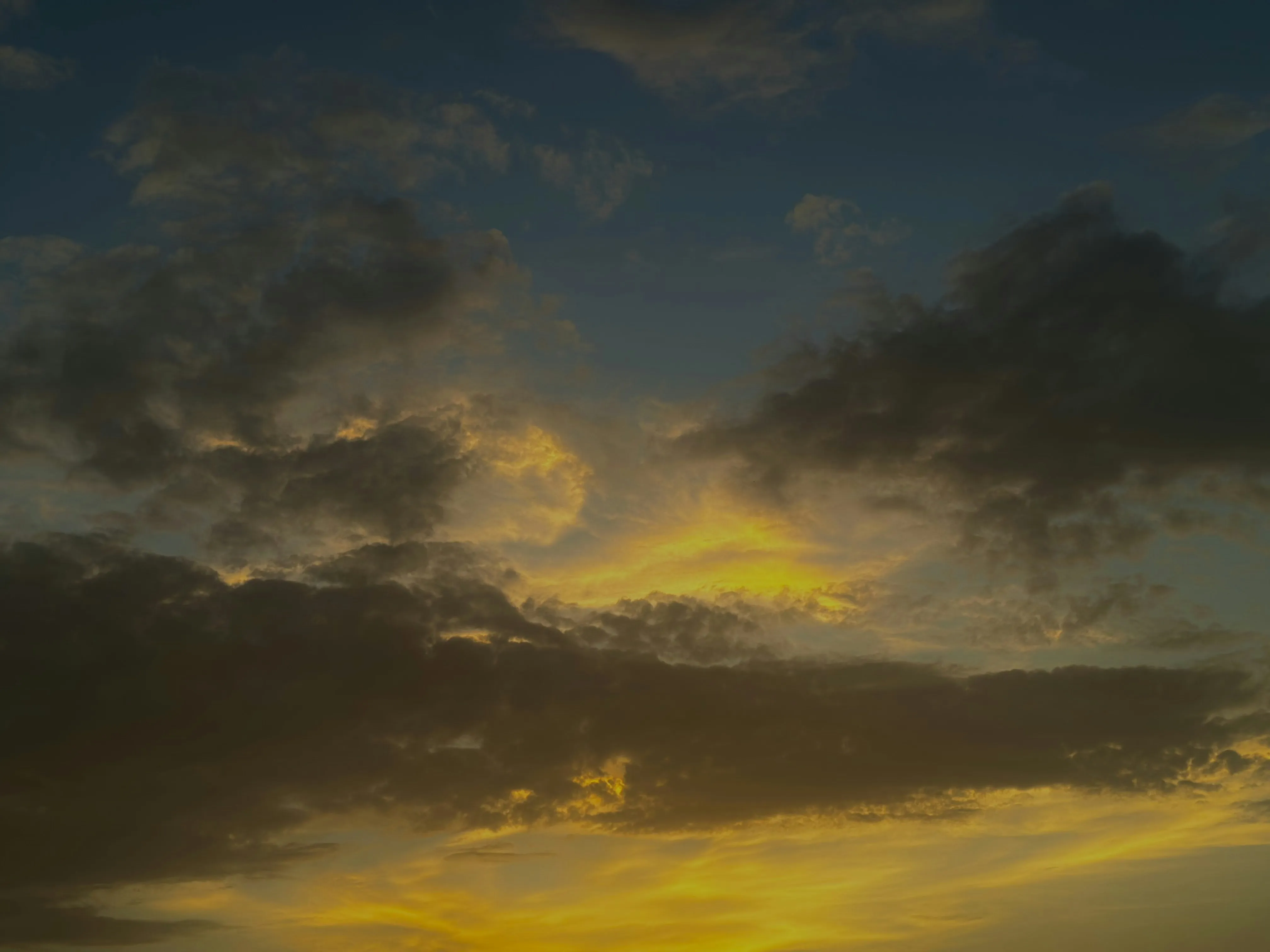 Dramatic Sunset with Dark Clouds Over Landscape Wallpaper