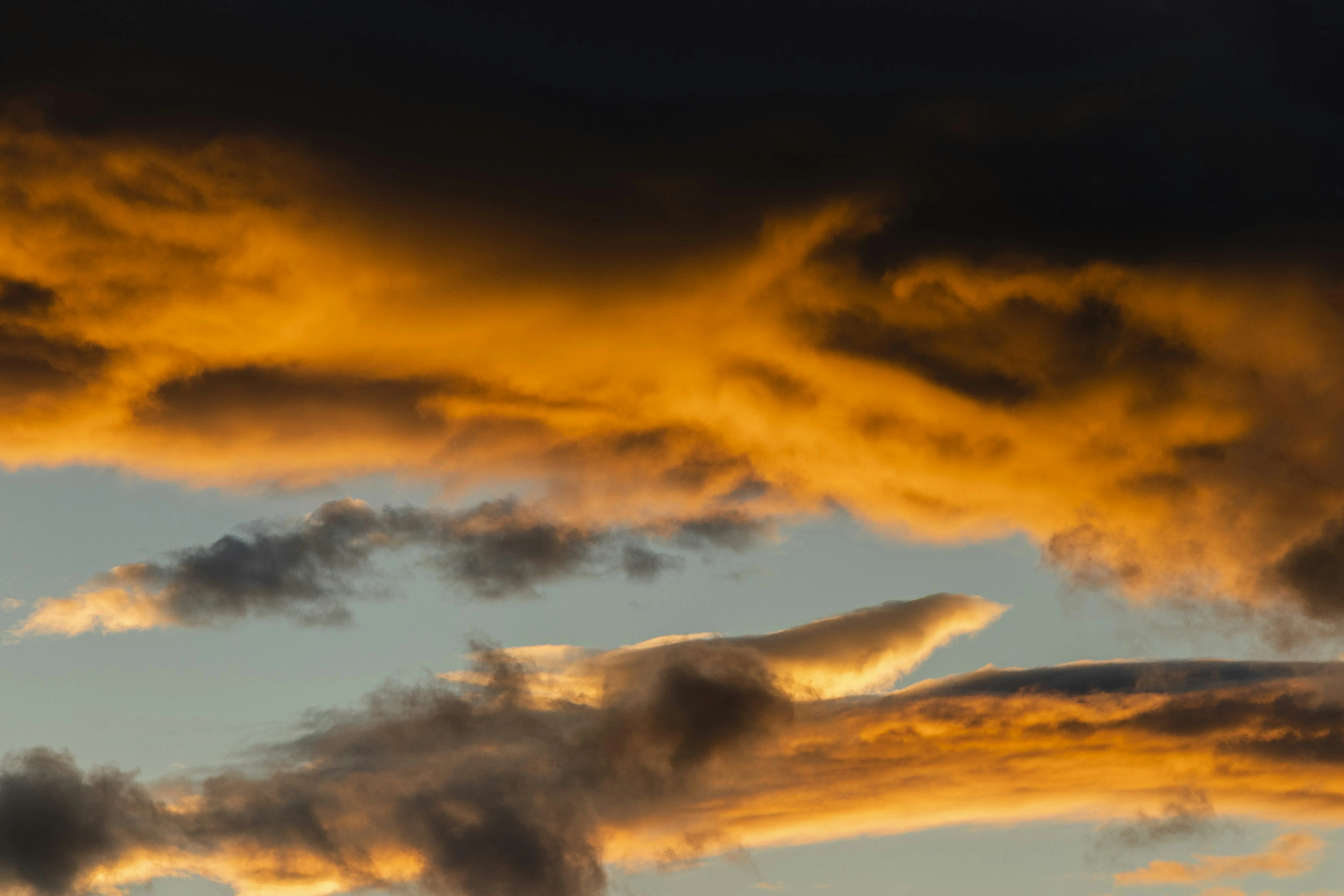 Fiery Orange Clouds Lighting Up the Evening Sky Wallpaper