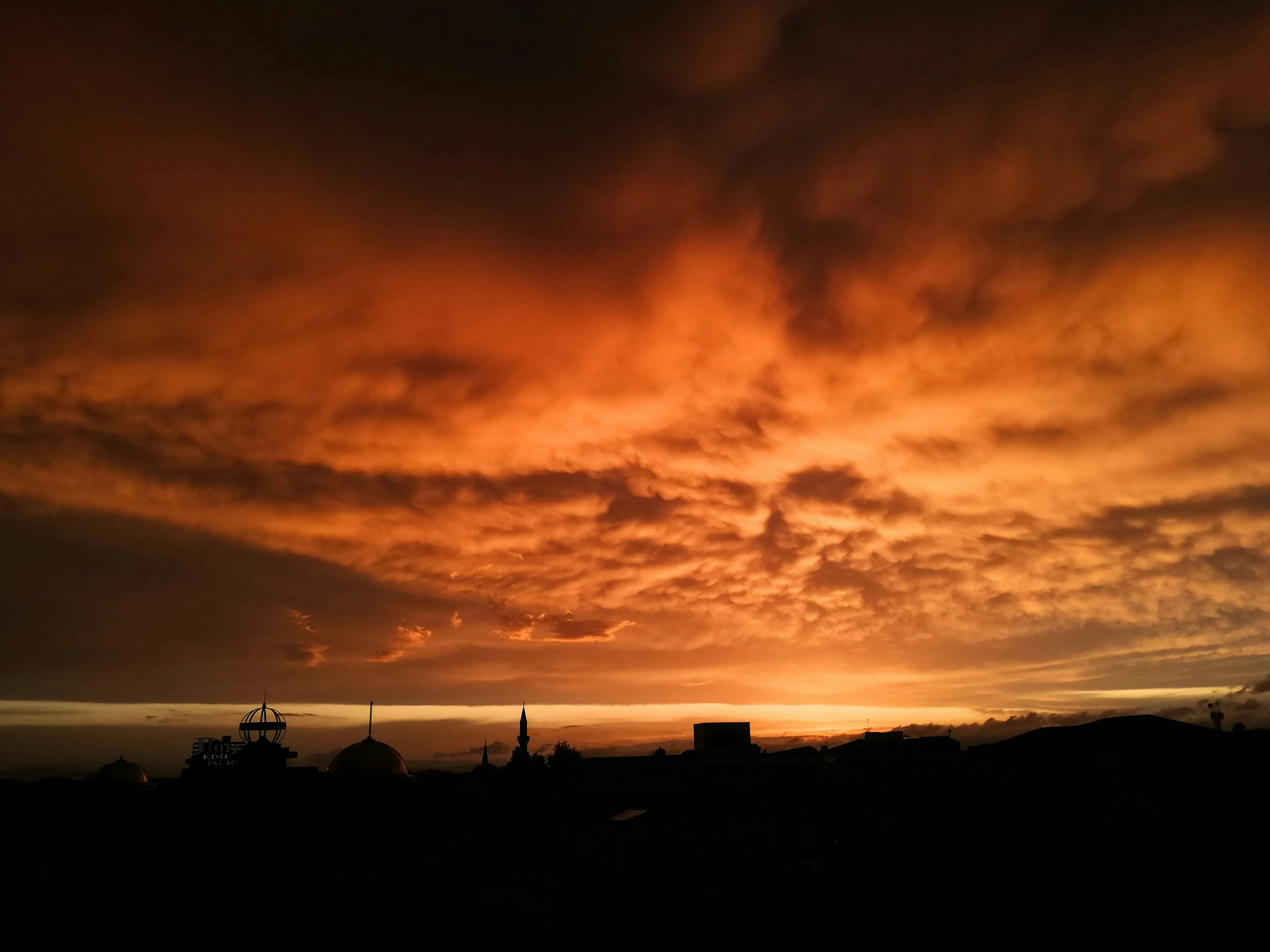 Fiery Orange Sunset Casting Glow Over Dark Silhouettes