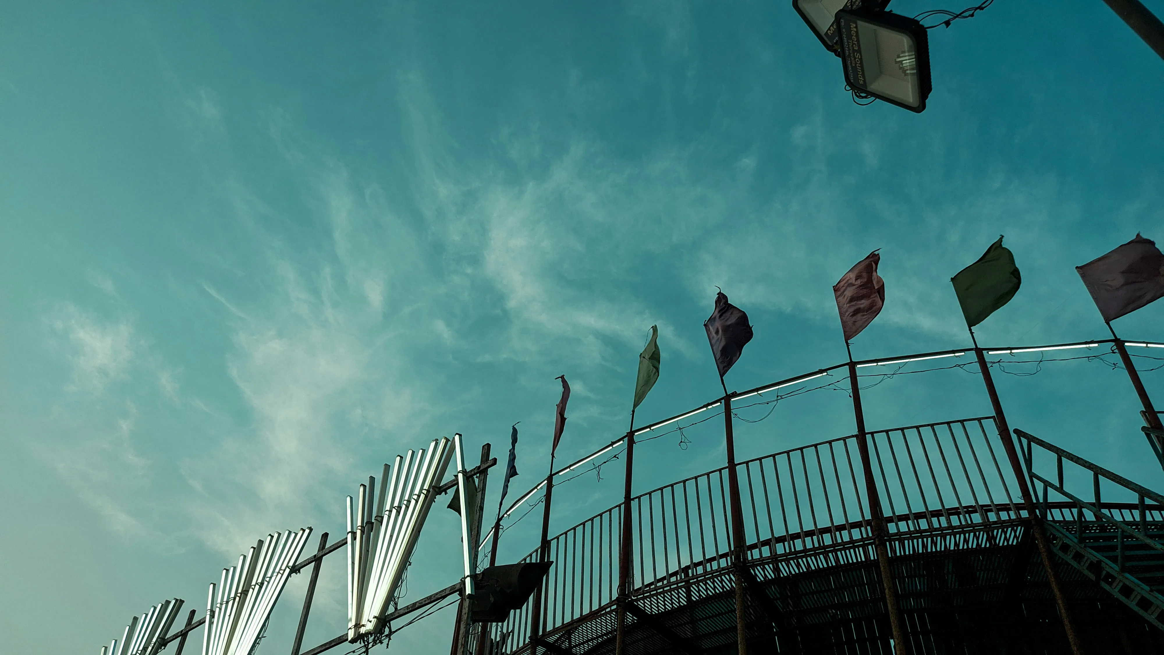 Flags Fluttering Above Stadium Under Clear Blue Sky