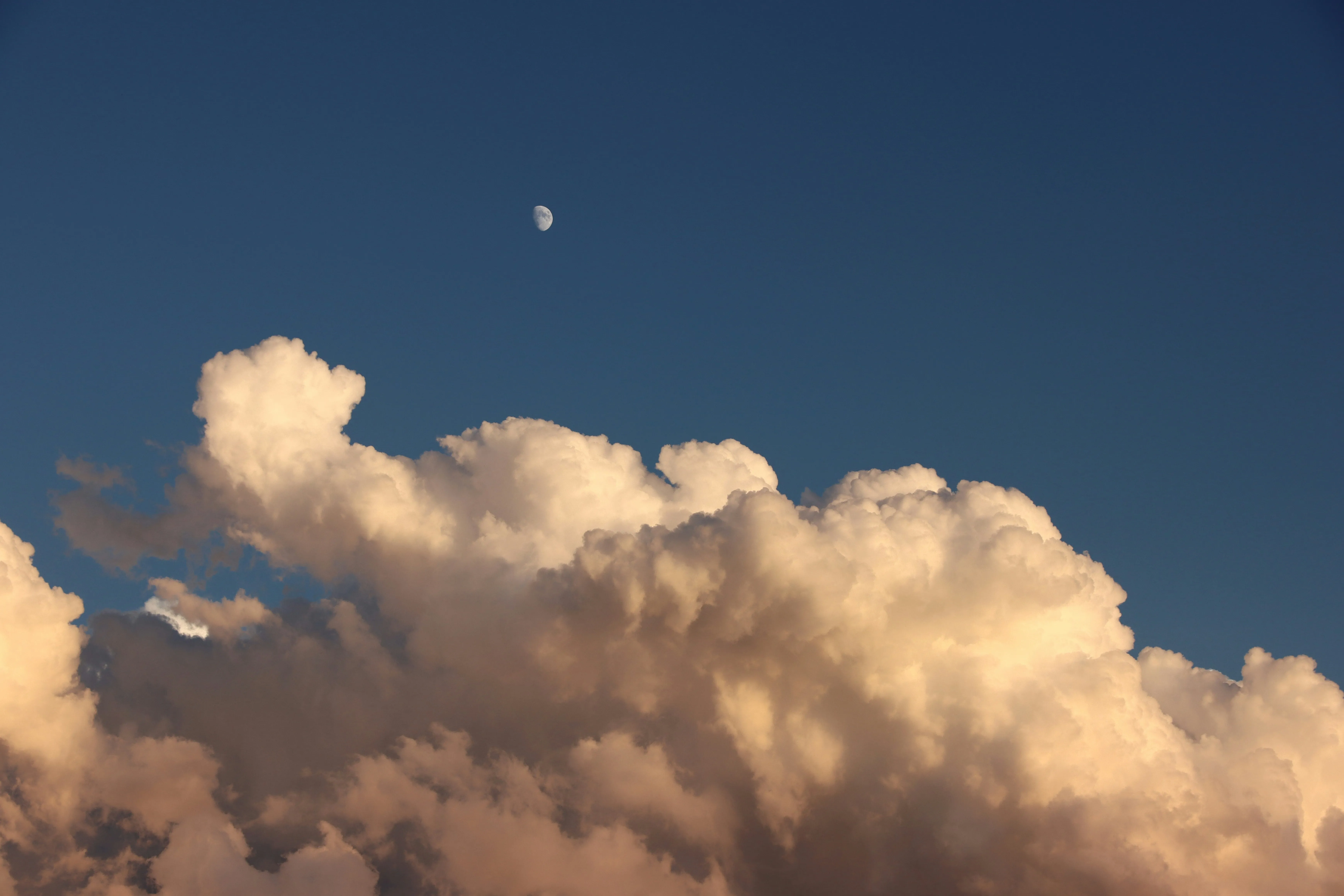 Fluffy Clouds Glowing Brightly During a Clear Blue Sky Sunset