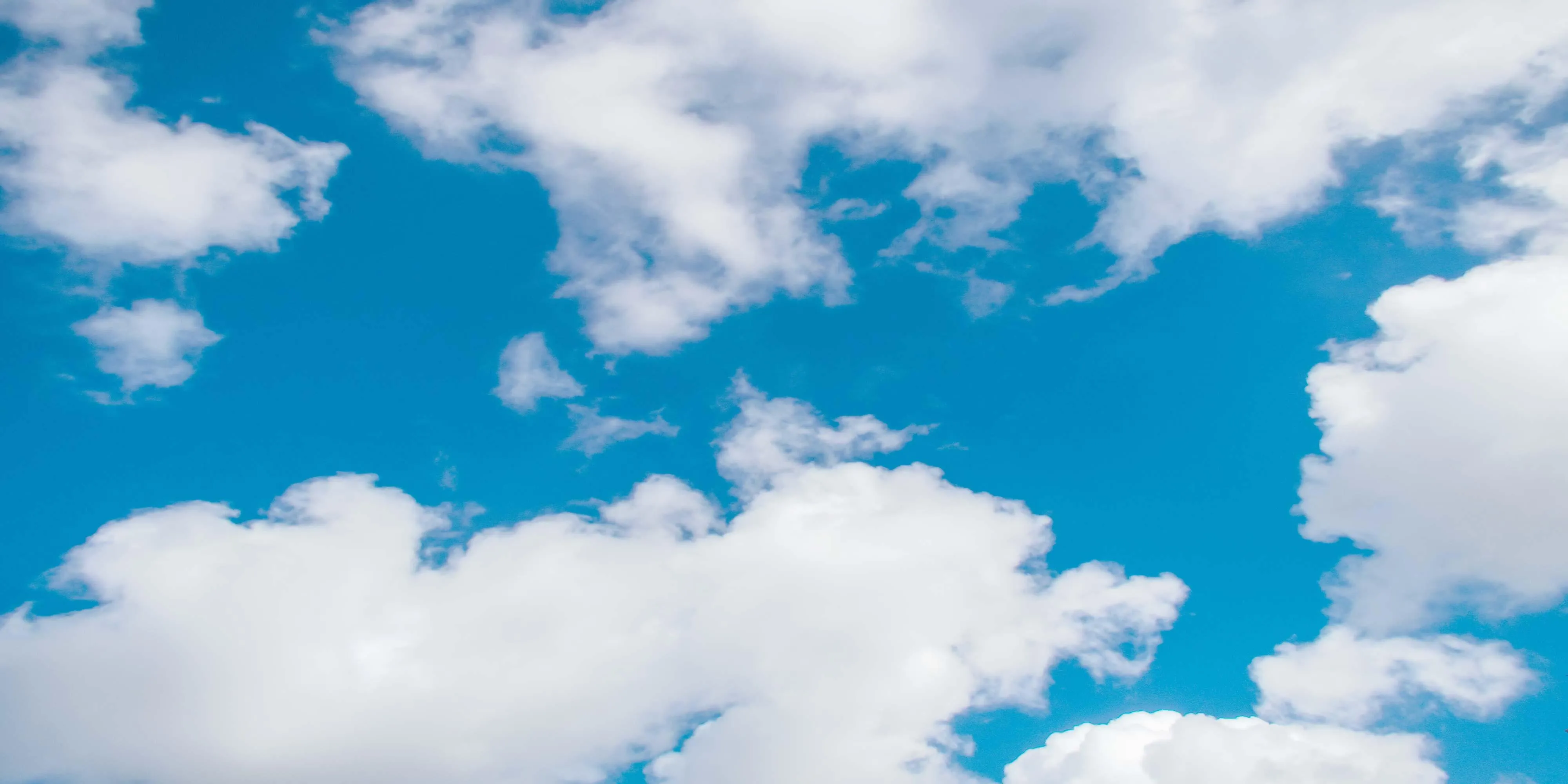 Fluffy White Clouds in a Bright Blue Sky HD Wallpaper