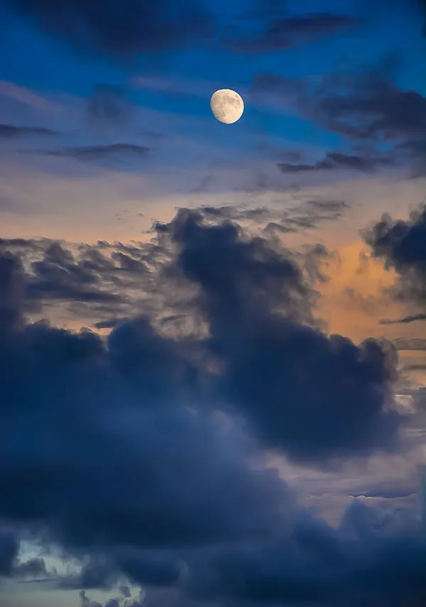 Full Moon Rising Through Dramatic Evening Clouds Image