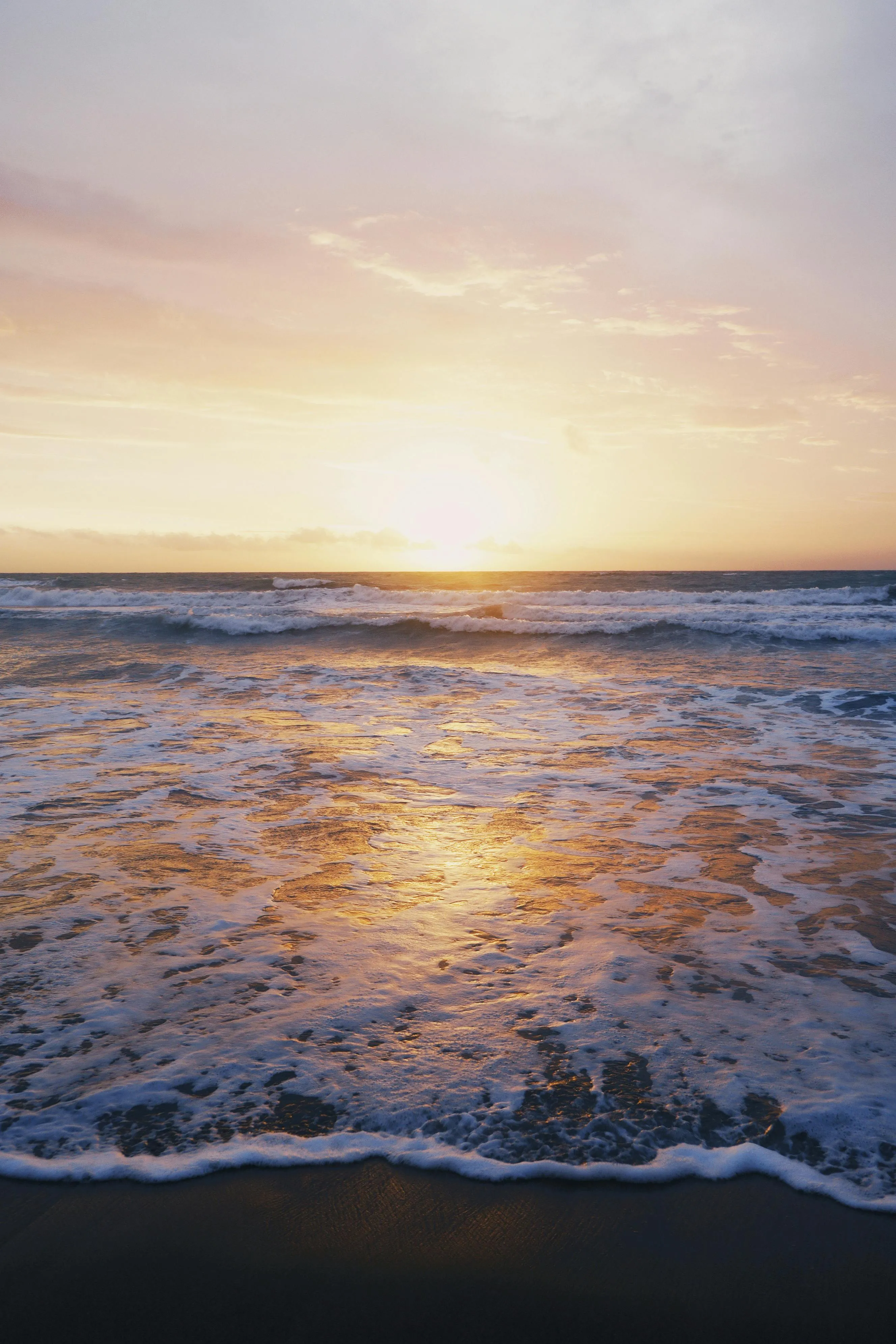 Gentle Waves Crashing on the Beach at Sunrise Wallpaper