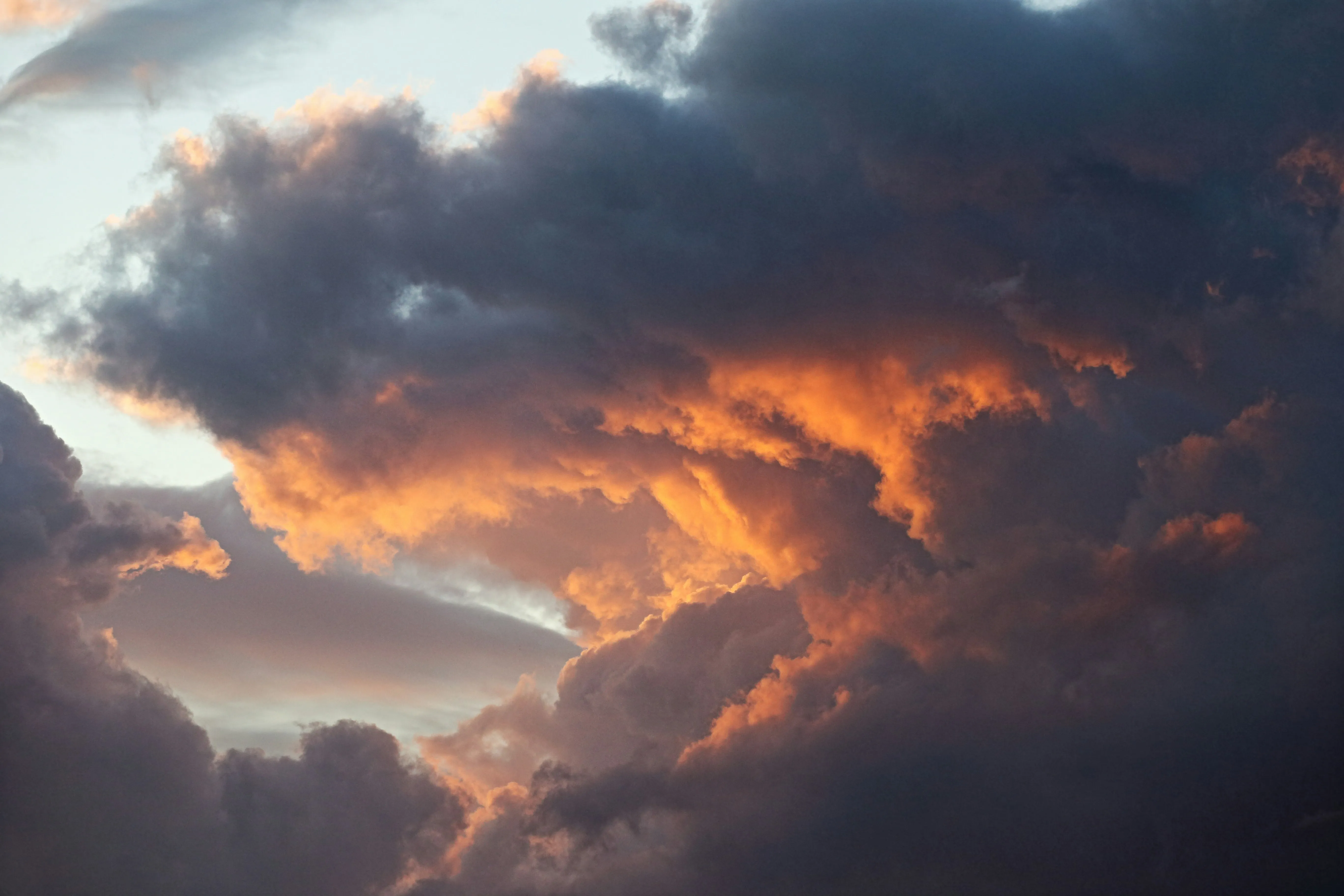 Glowing Orange Clouds at Sunset Over Calm Waters Wallpaper