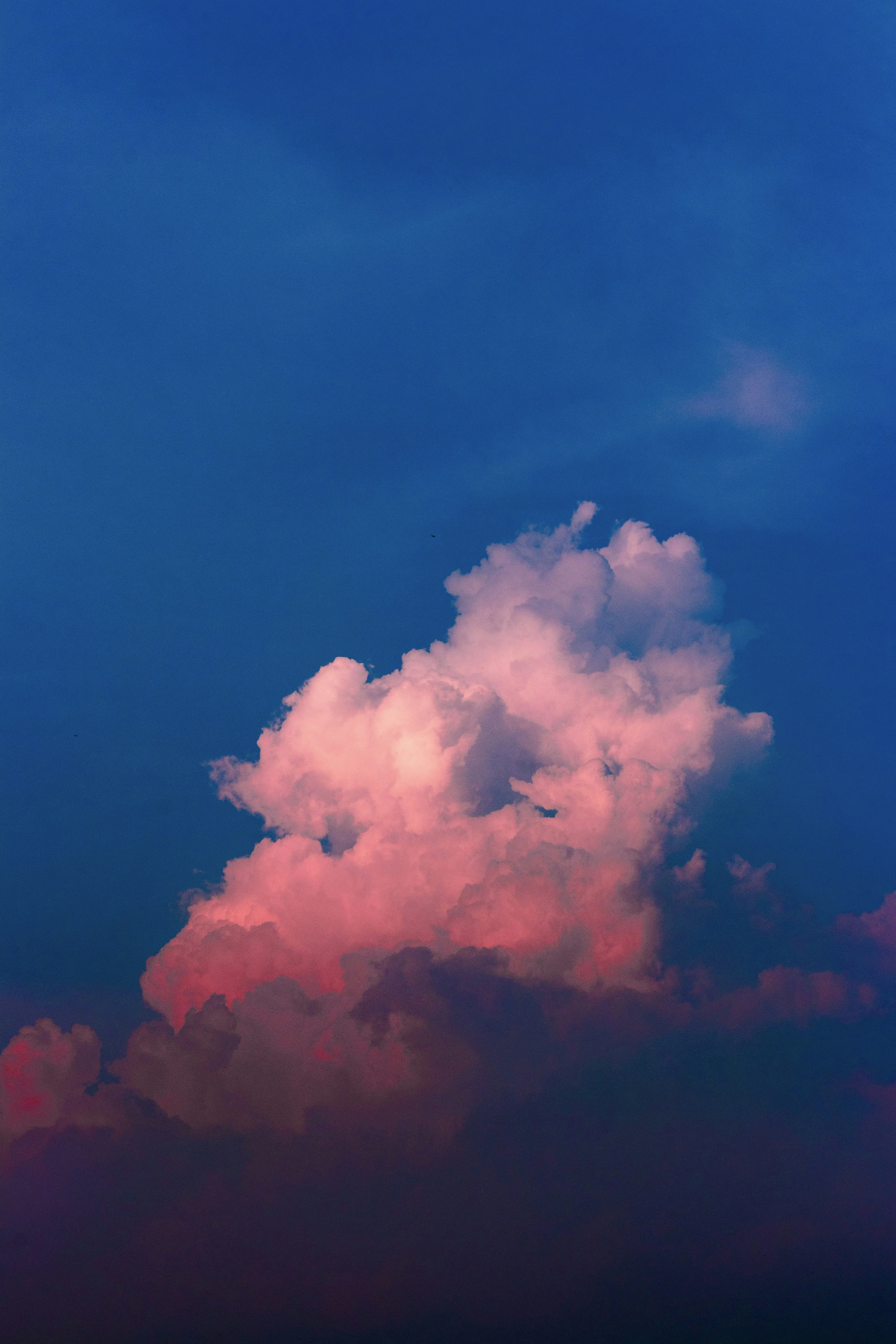 Glowing Pink Cloud Rising in a Deep Twilight Blue Sky
