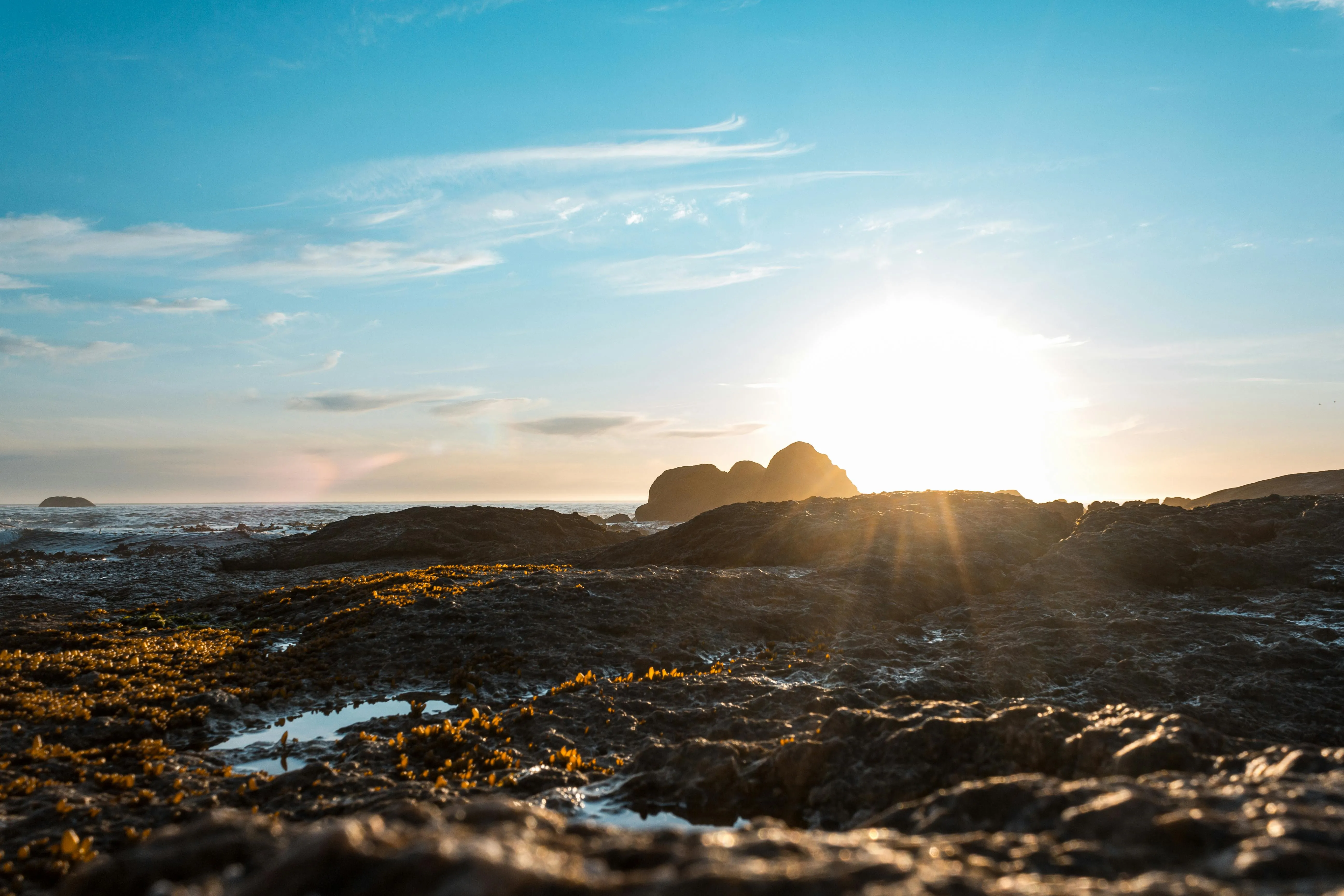 Golden Light Illuminates Coastal Hills and Ocean Sky